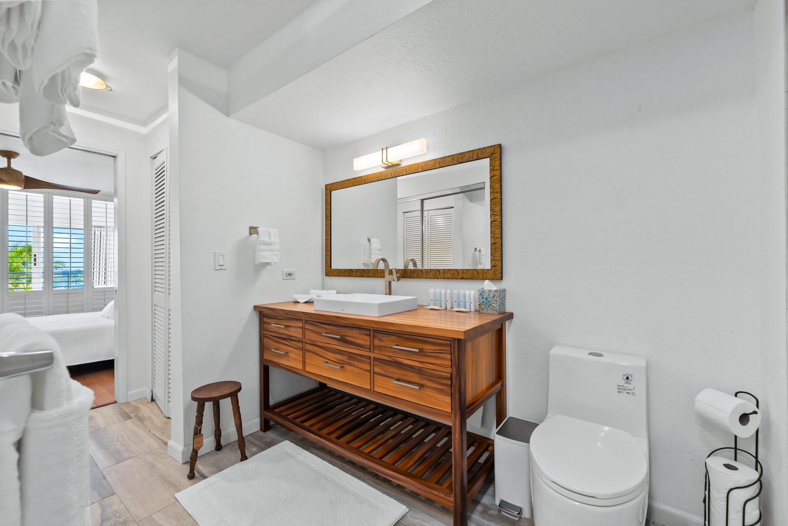 Honolulu Vacation Rentals, Colony Surf Retreat - Spa-inspired vanity with double mirrors, sleek lighting, and a natural wood finish that enhances the peaceful ambiance.