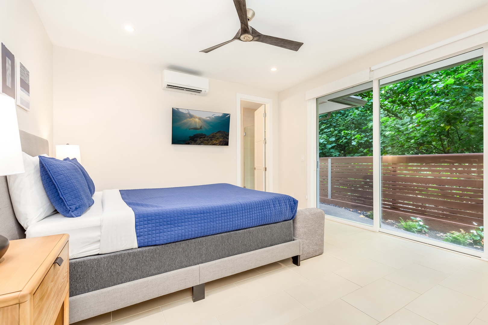 Laie Vacation Rentals, Majestic Mahakea Oceanfront Oasis - Bright, cheerful third guest bedroom featuring vibrant colors and a patio entrance.