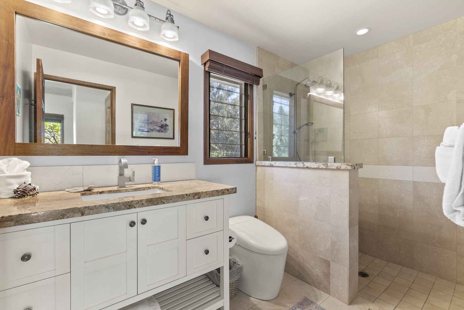 Haleiwa Vacation Rentals, Maluhia Beach House - Spacious bathroom with a walk-in shower, elegant vanity, and natural wood accents.