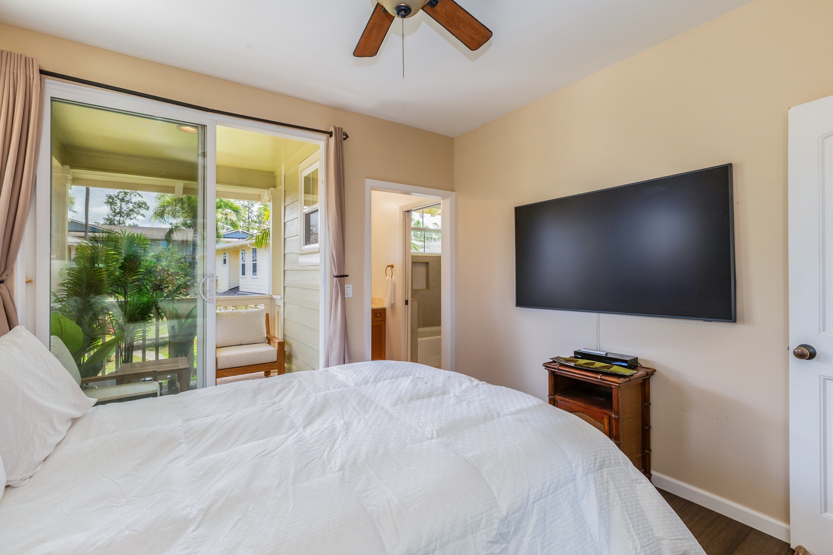 Princeville Vacation Rentals, Pualani Villa - Unwind in the second bedroom with a queen-size bed and a mounted TV for entertainment.