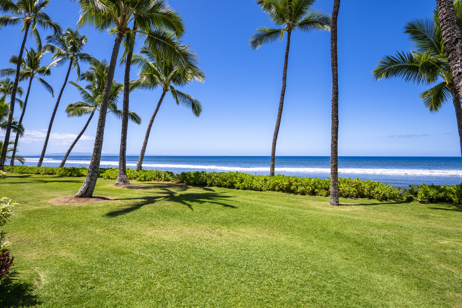 Lahaina Vacation Rentals, Puamana 240-3 - Gaze out at the tranquil shoreline, where waves meet the lush landscape.