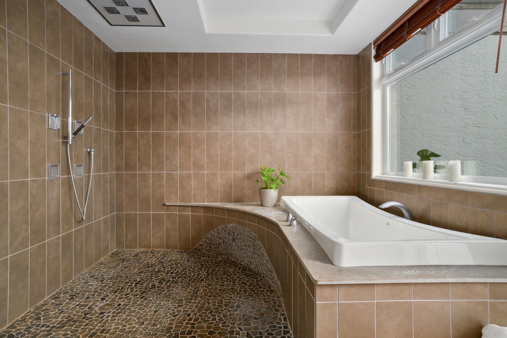 Princeville Vacation Rentals, Kaiulani #8 - Soaking tub by the window, with an open walk-in shower right beside it in the primary bath.