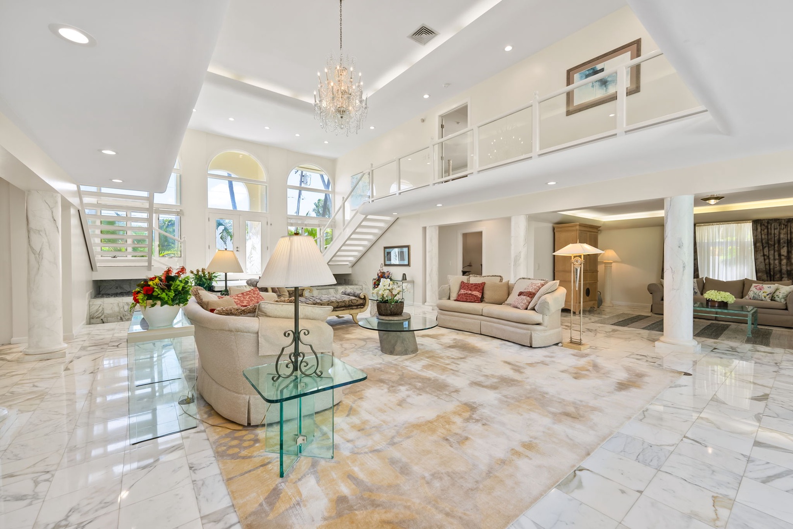 Honolulu Vacation Rentals, Kahala Oasis - Elegant living room with a grand chandelier, plush seating, and stylish decor for an inviting atmosphere.