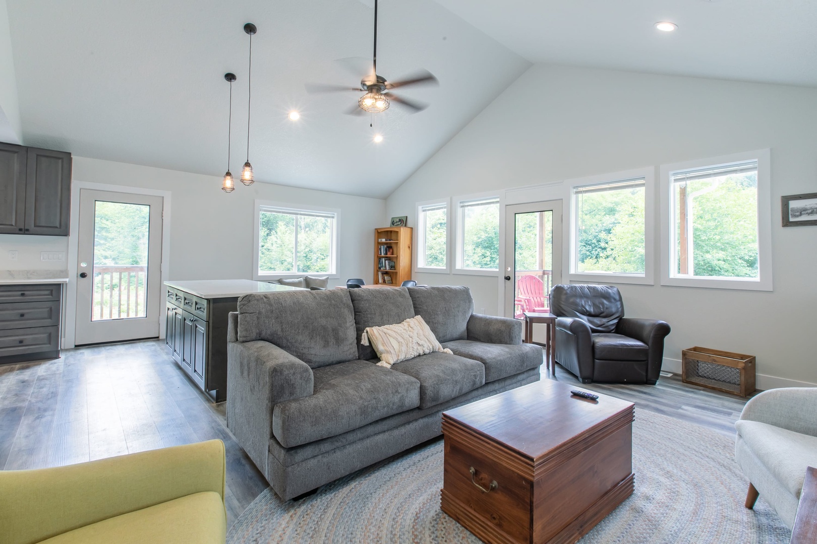 Nehalem Vacation Rentals, Nehalem Coastal Oasis - The main house includes an open-concept living area equipped with various seating options, including a full-size pullout couch, a 55” flat-screen Smart TV, deck access, books, games