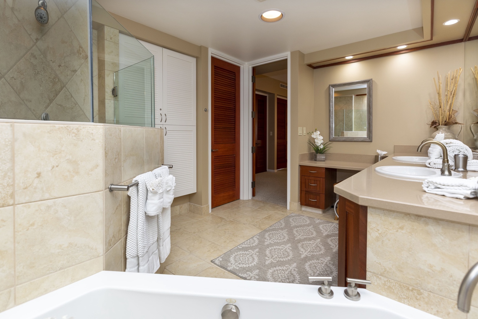 Kamuela Vacation Rentals, Mauna Lani Point E105 - The spacious primary bathroom is beautifully designed with dual vanities and luxury finishes.