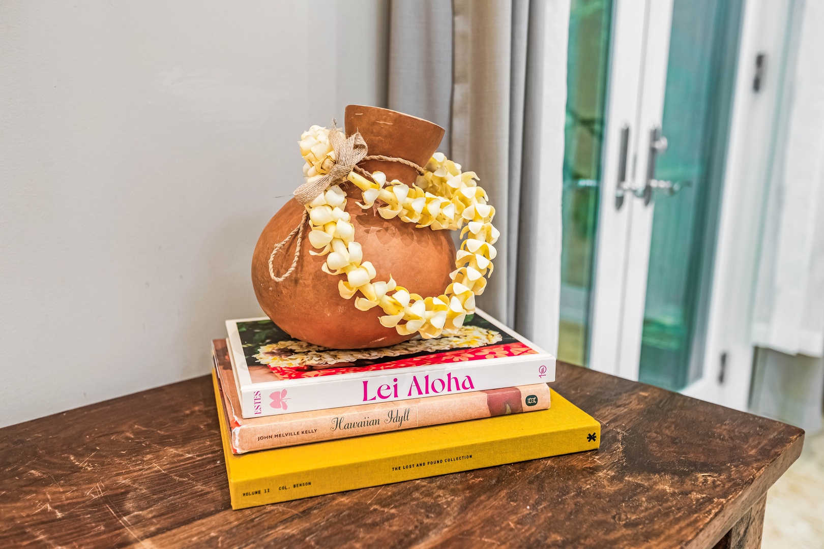 Honolulu Vacation Rentals, Pili Pono - Hawaiian décor detail with books and traditional adornments.