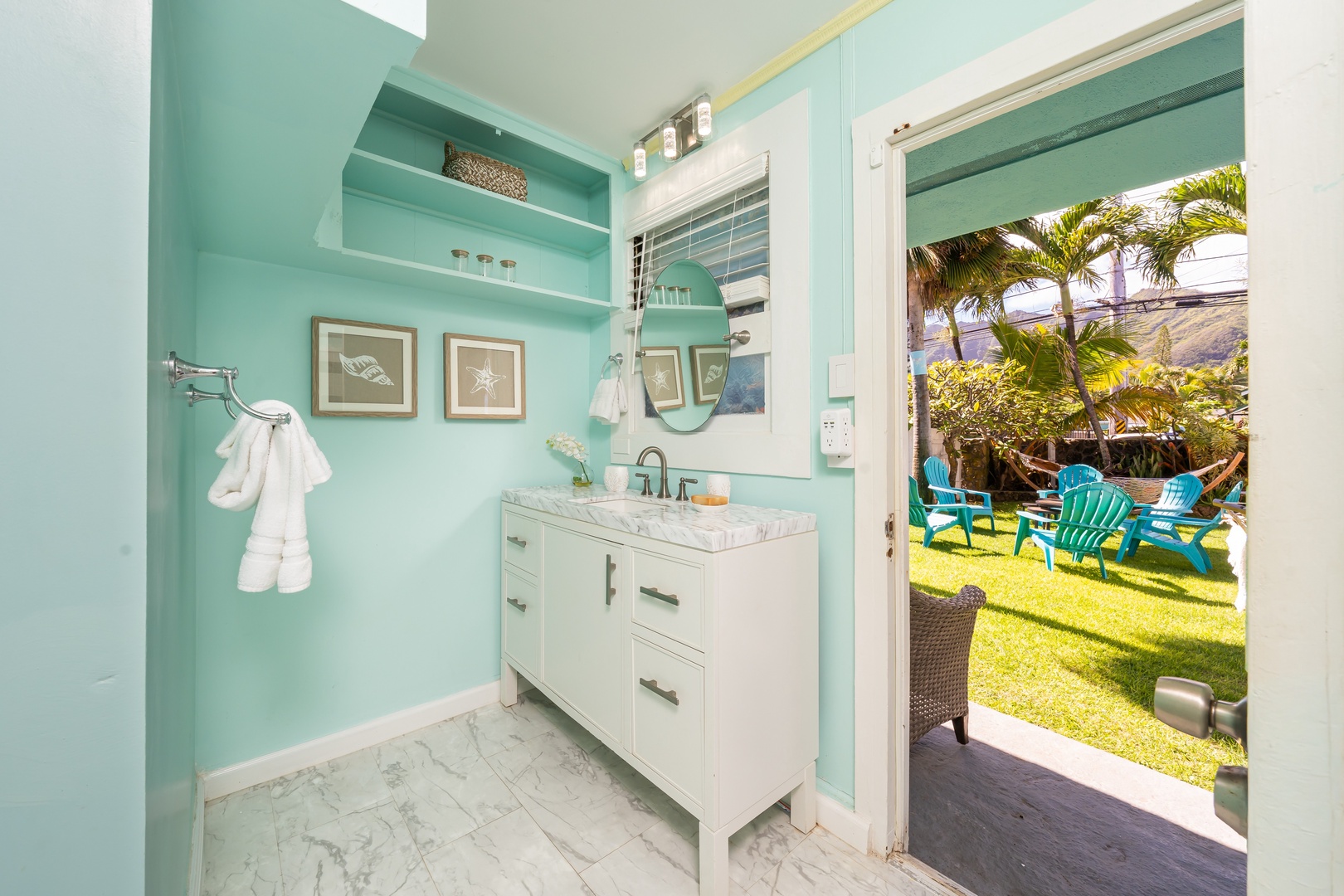 Hauula Vacation Rentals, Private Beach Paradise - Bright bathroom opening to the outdoors, with turquoise tones and a breezy backyard connection.