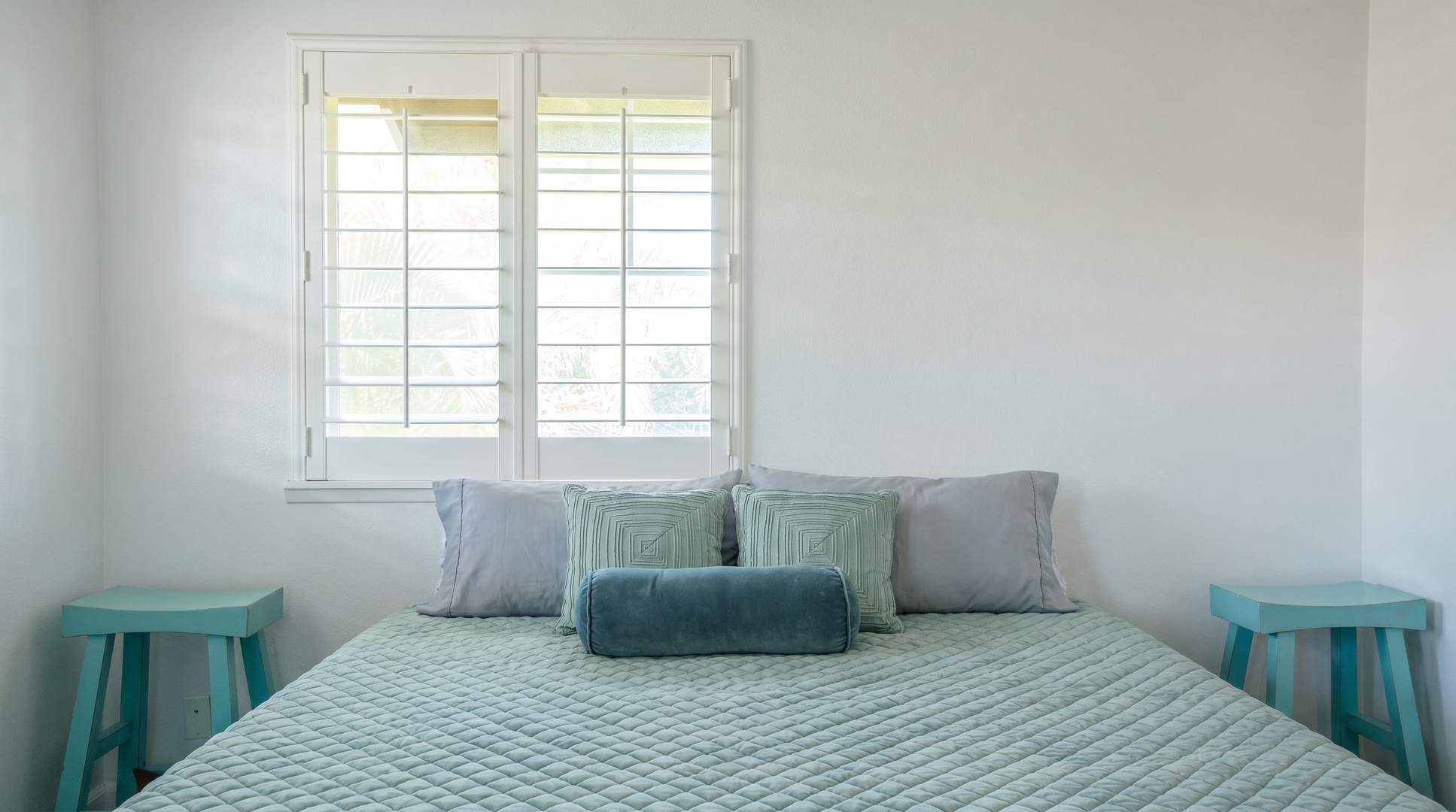 Stay in bed late with the teal pillows piled up and the shutters overhead.