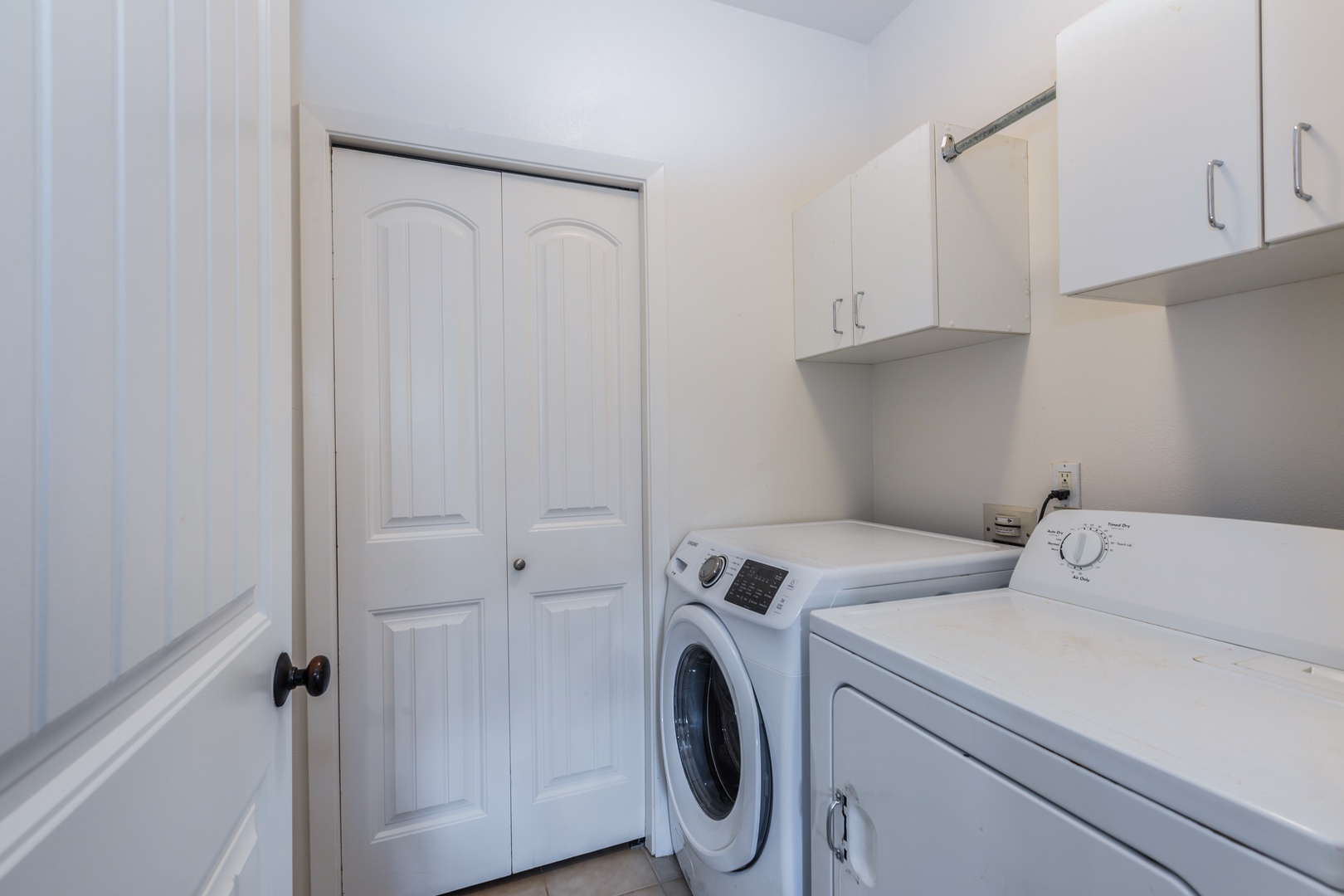 Princeville Vacation Rentals, Pualani Villa - Fully equipped laundry room with a washer, dryer, and storage cabinets.