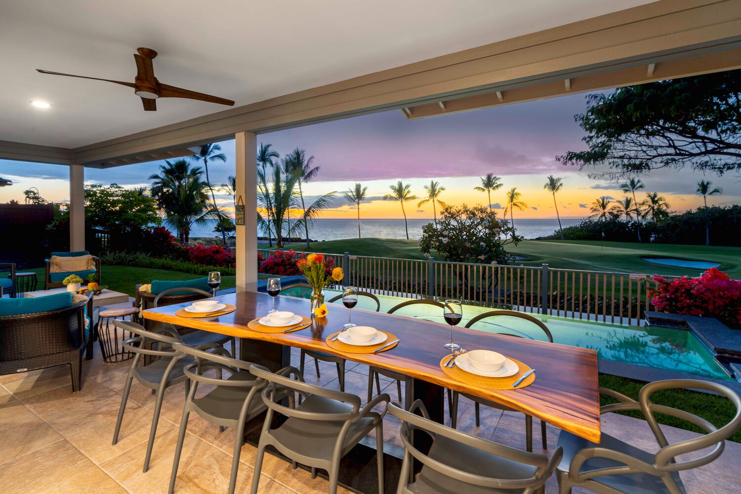Kailua-Kona Vacation Rentals, Holua Kai #26 - Outdoor dining area overlooking a tranquil pool and ocean at dusk.