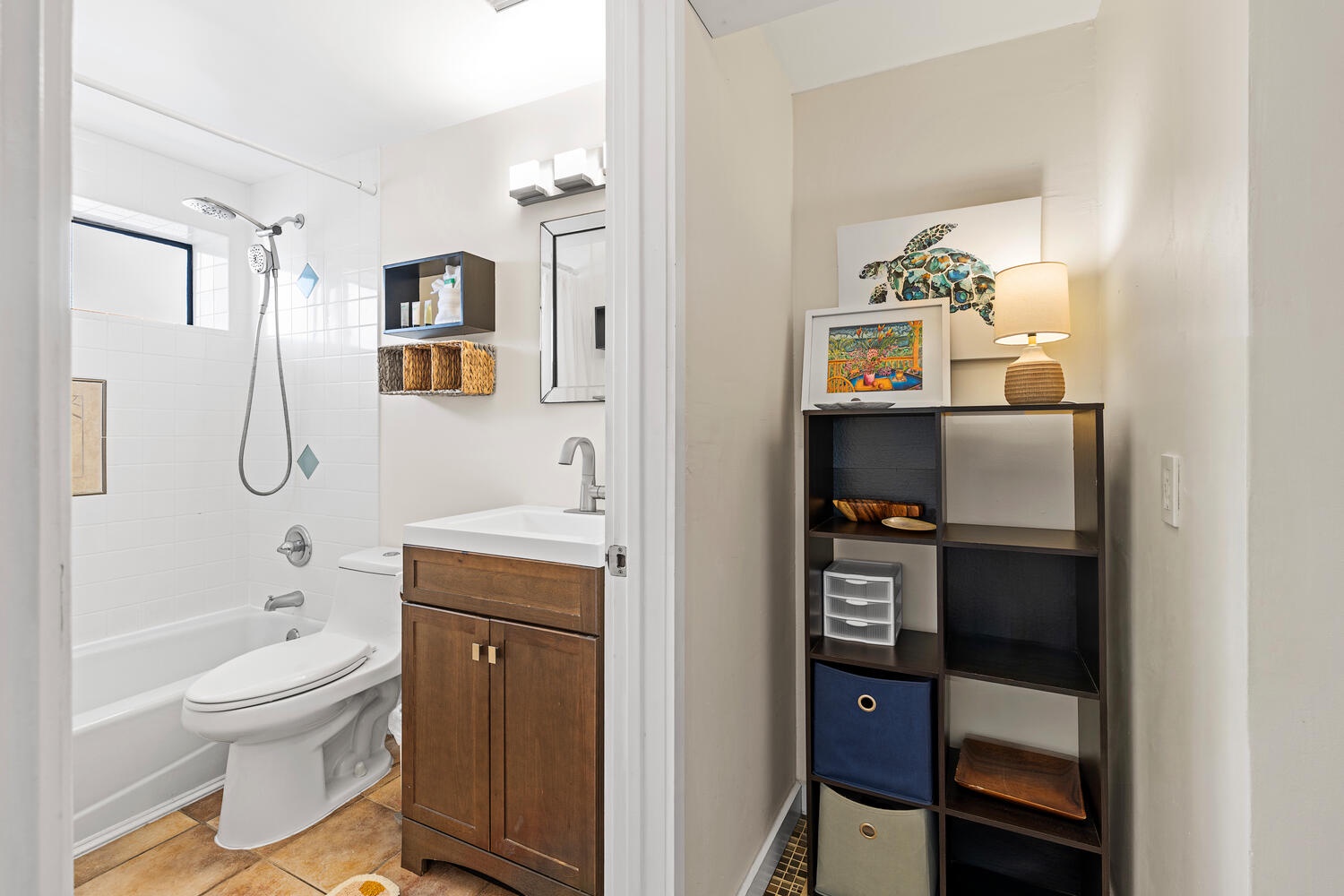 Kailua Kona Vacation Rentals, Kona Plaza 201 - Step into your thoughtfully designed bathroom featuring a relaxing tub-shower combo and warm wood vanity that makes your daily routine feel like a spa retreat.