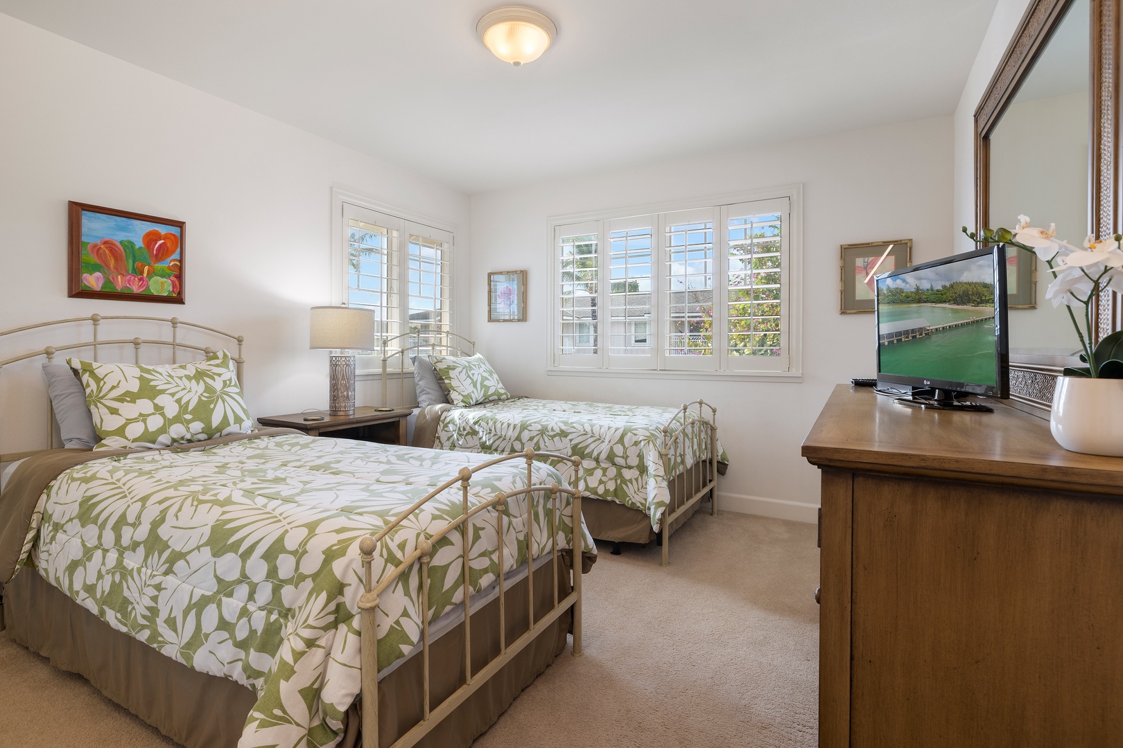 Unwind in your bright twin bedroom with tropical-print linens and peaceful garden views streaming through large windows.