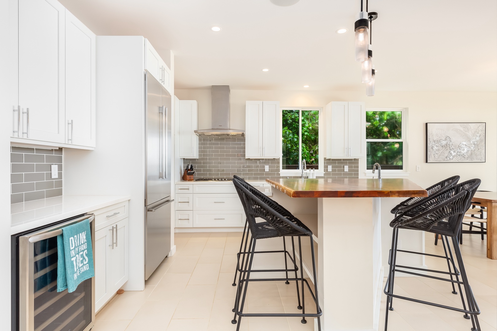 Laie Vacation Rentals, Majestic Mahakea Oceanfront Oasis - Kitchen island with bar seating and a backdrop of modern cabinetry and stainless appliances.