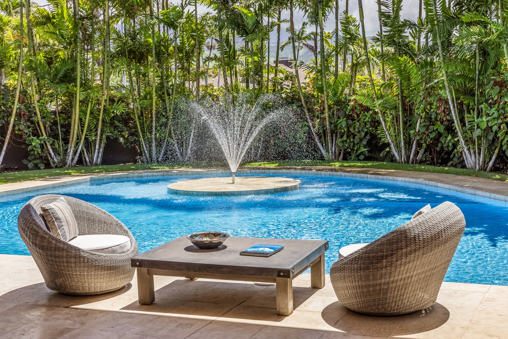 Honolulu Vacation Rentals, Kahala Grand Splendor - A tranquil poolside lounge area with a fountain and lush greenery creates a serene, tropical escape.