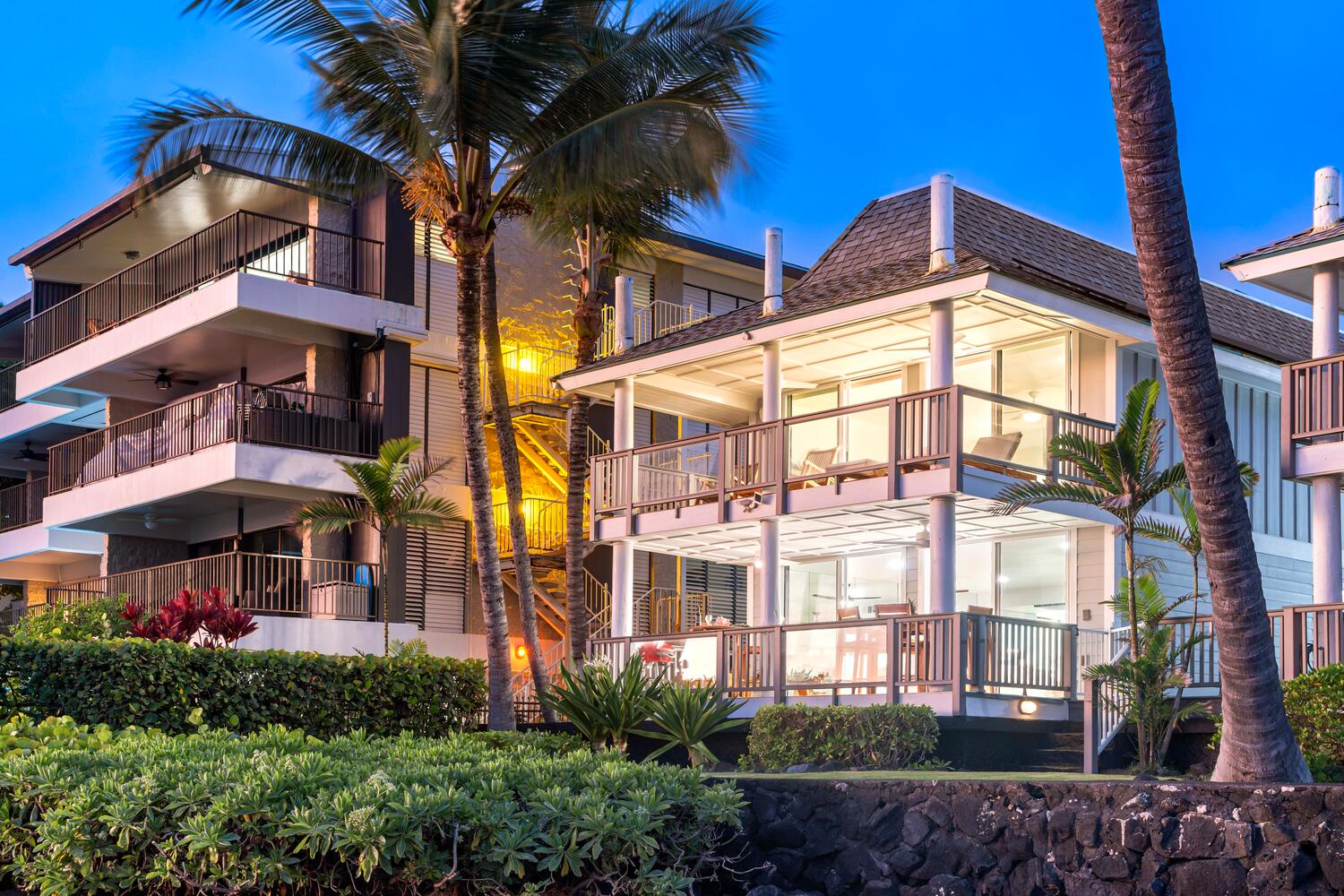 Kailua Kona Vacation Rentals, Hale Kai O'Kona #7 - Evening view of the building exterior illuminated by soft lighting.