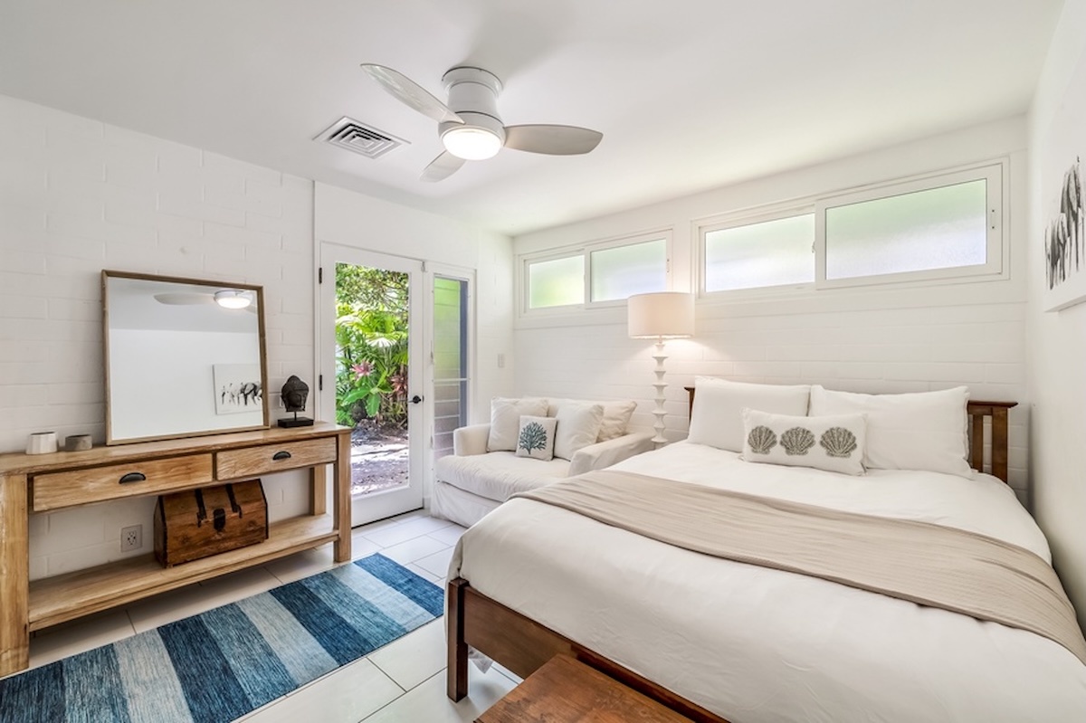 Kailua Vacation Rentals, Hale Ohana - Guest Bedroom 2 features a queen bed, garden view, love seat, and ceiling fan.