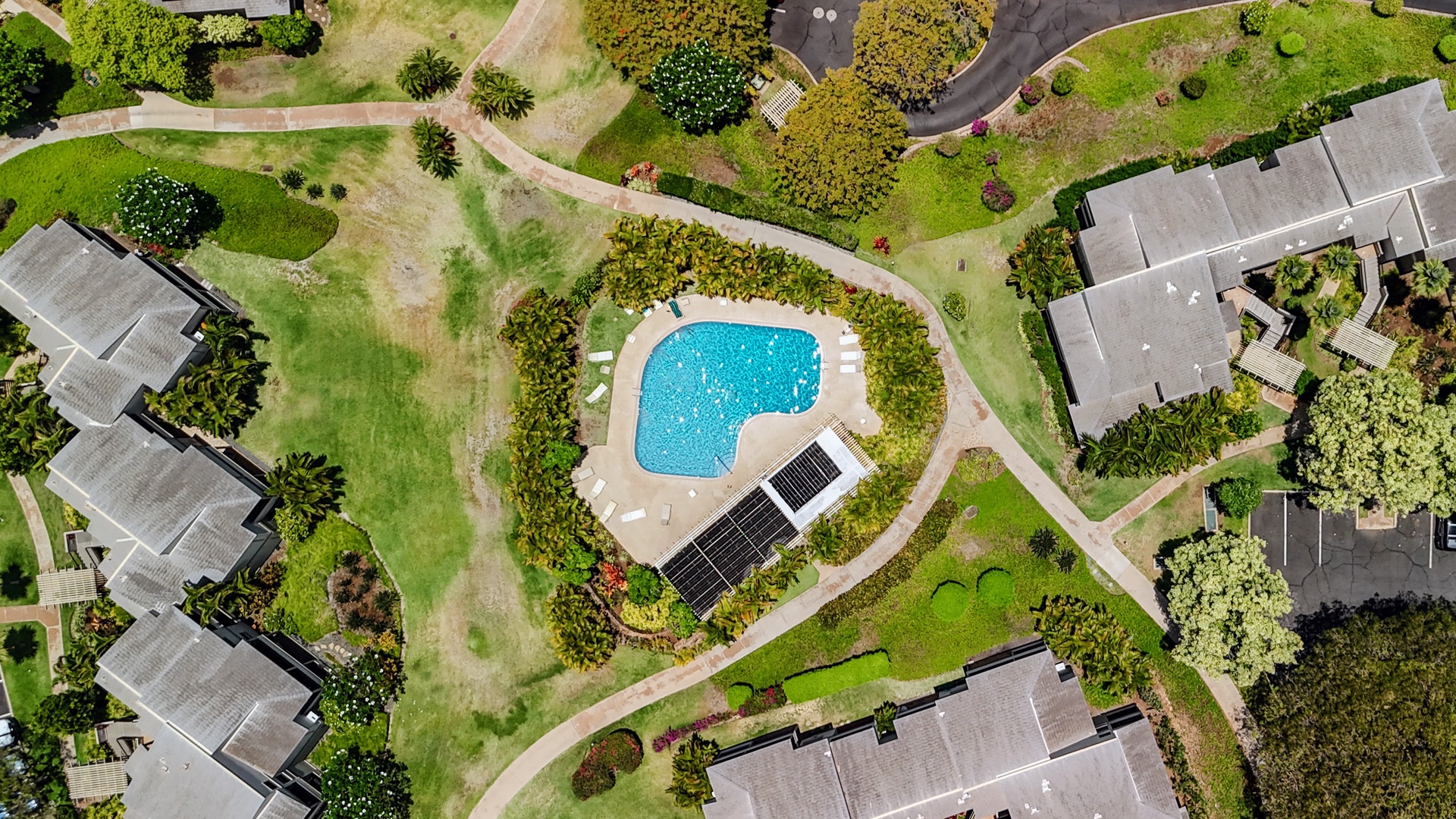 Kihei Vacation Rentals, Wailea Ekolu 204 - From above, the pool reads like a bright blue teardrop tucked into a fold of green lawn and rooftops.