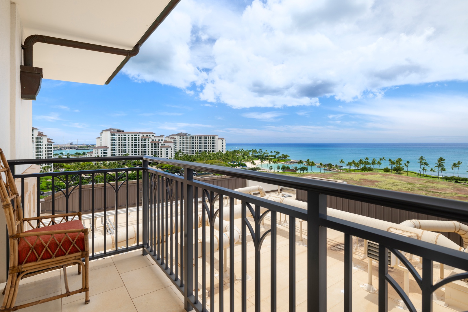 Panoramic ocean views stretch endlessly from this private lanai, where tropical palms frame turquoise waters below.
