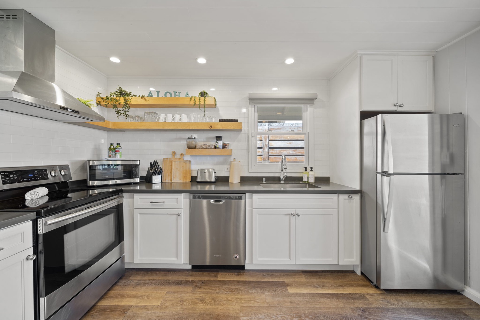 Haleiwa Vacation Rentals, Hale Nalu (Lower Level) - Fully equipped kitchen with stainless steel appliances and floating shelves for a modern touch.