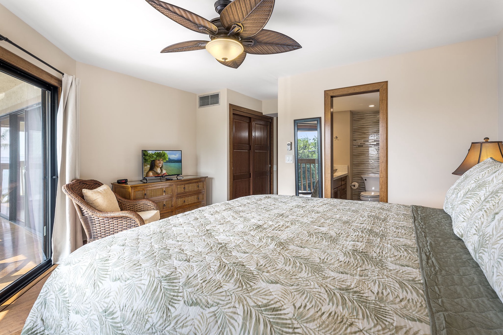 Kailua Kona Vacation Rentals, Royal Kahili 401A - Spacious primary bedroom with a king-sized bed, additional seating, and a desk area.