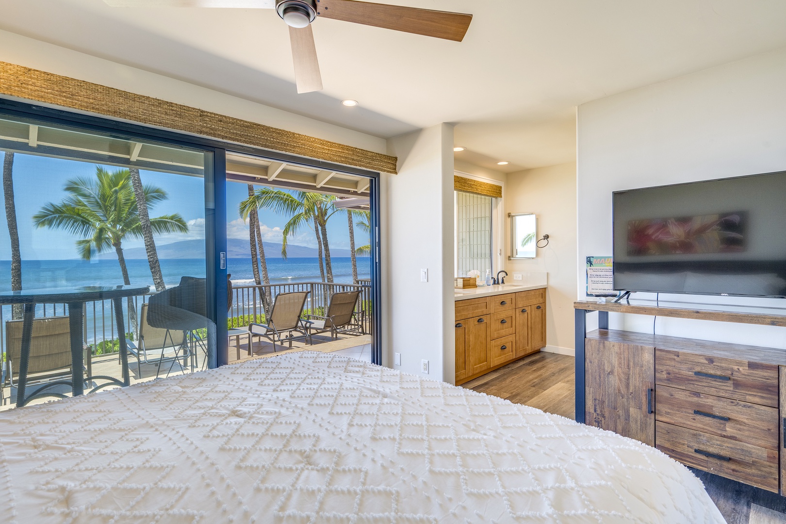 Lahaina Vacation Rentals, Puamana 240-3 - Relax in this elegant bedroom featuring a luxurious king-size bed and stunning oceanfront views.