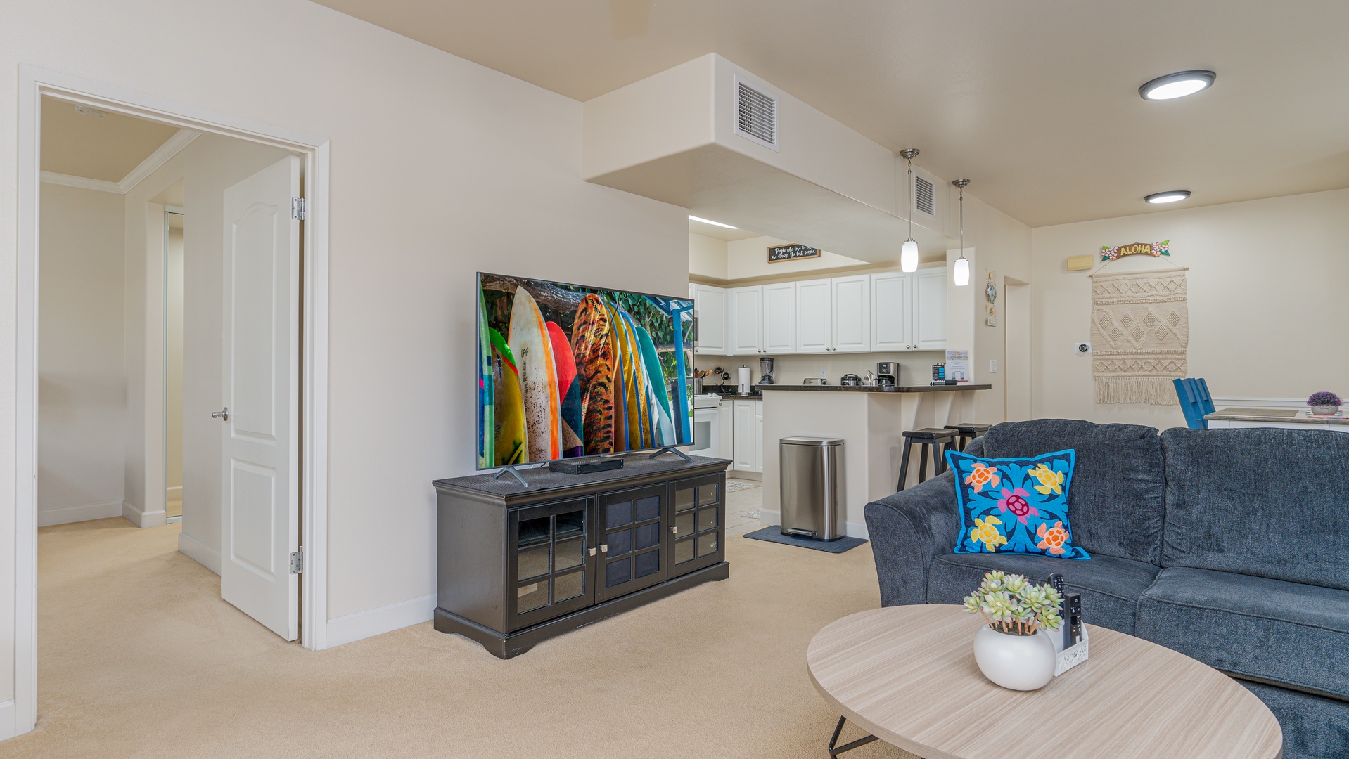 Kapolei Vacation Rentals, Ko Olina Kai 1027A - The open floor plan for the kitchen, living and dining room and the TV with storage.