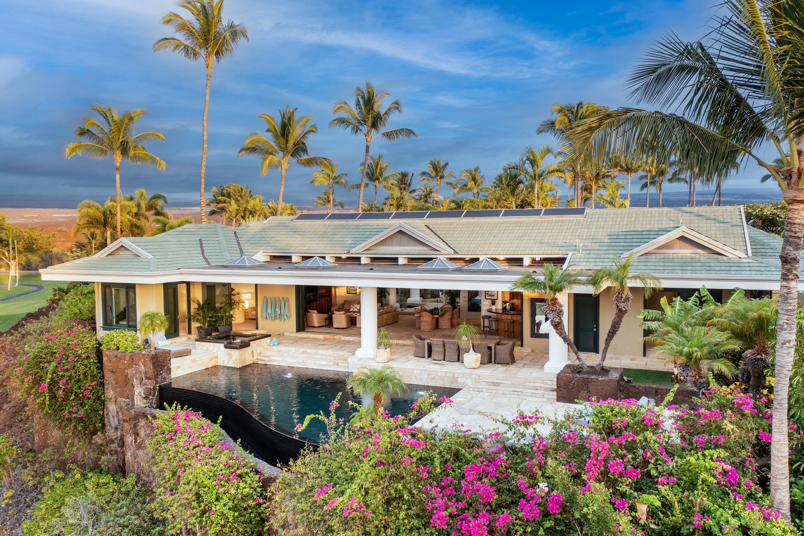 Kamuela Vacation Rentals, Canoe House at Champion Ridge - Lush tropical landscape surrounds the pool, offering a serene and colorful backdrop.