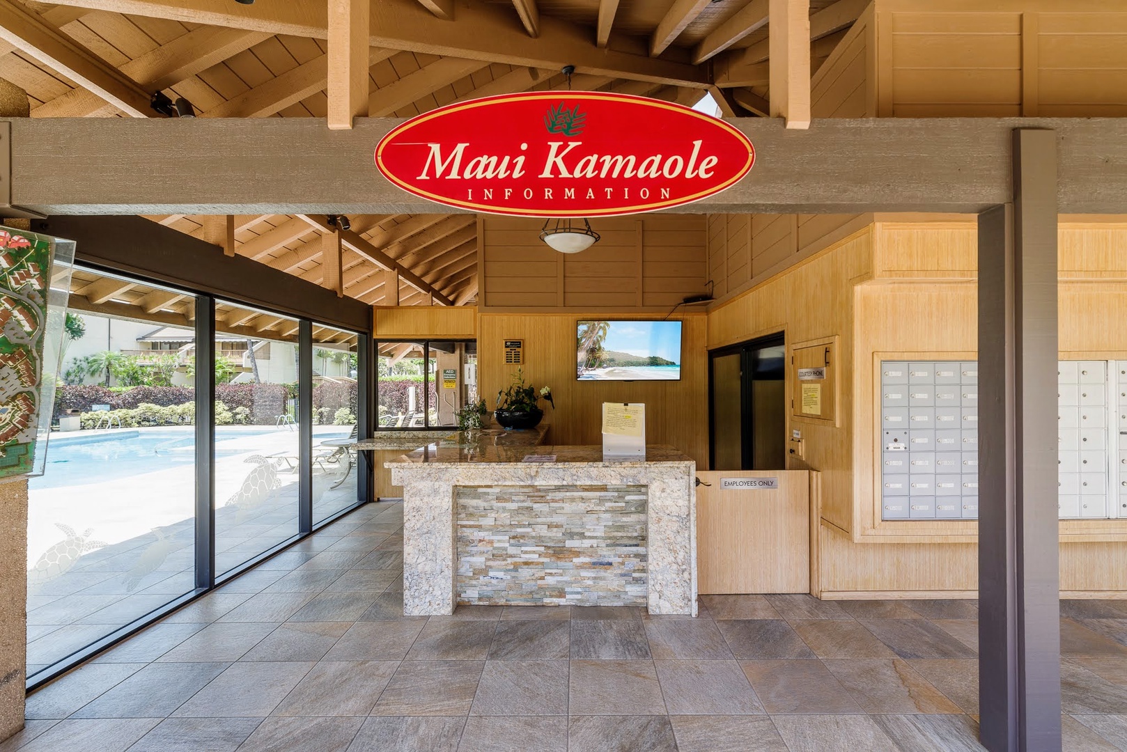 Kihei Vacation Rentals, Maui Kamaole E103 - Check-in starts here, at the Maui Kamaole information desk with the pool just past the glass.