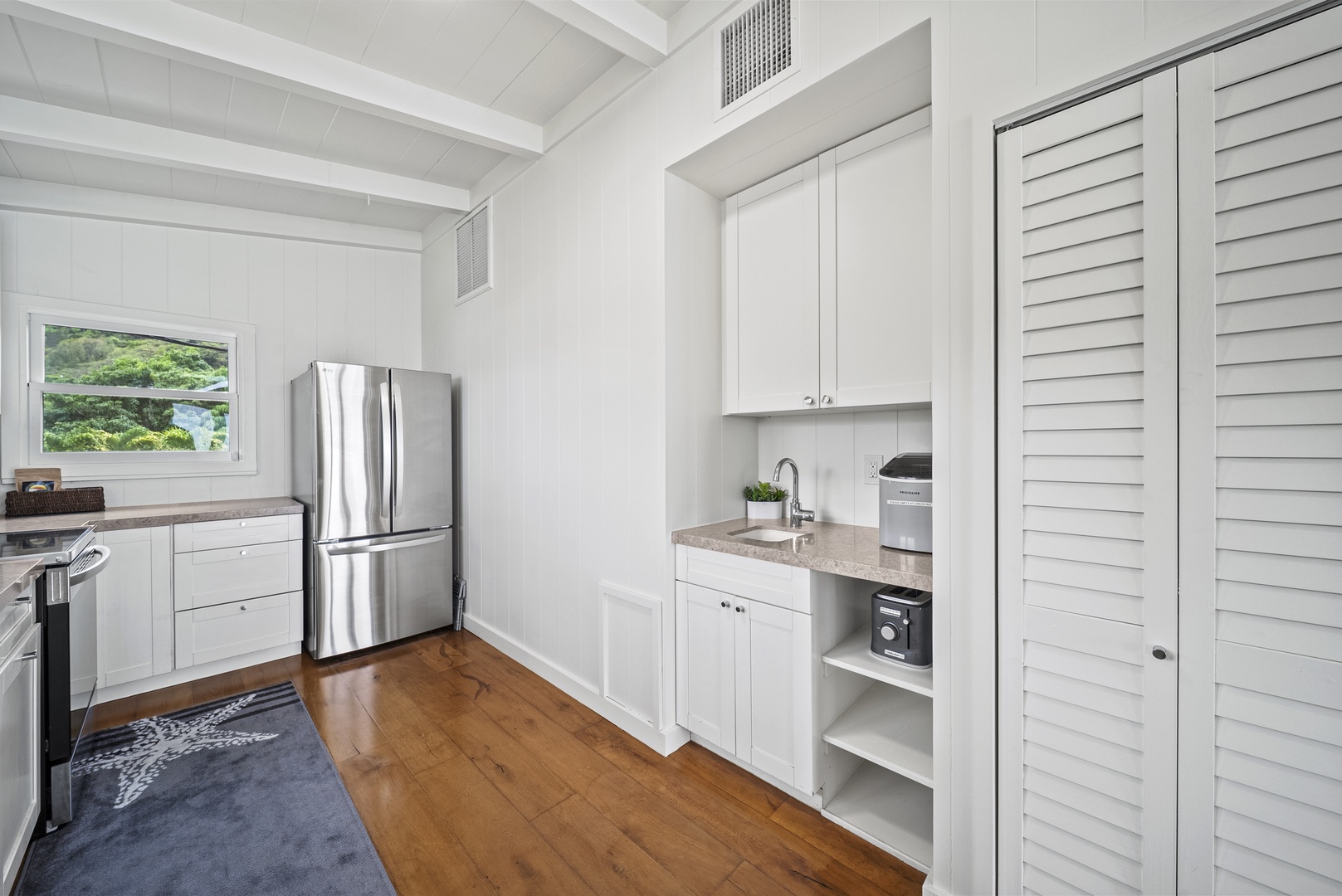 Haleiwa Vacation Rentals, Surfer's Paradise - Additional kitchen angle showcasing upgraded appliances and organized storage for a seamless vacation cooking experience.