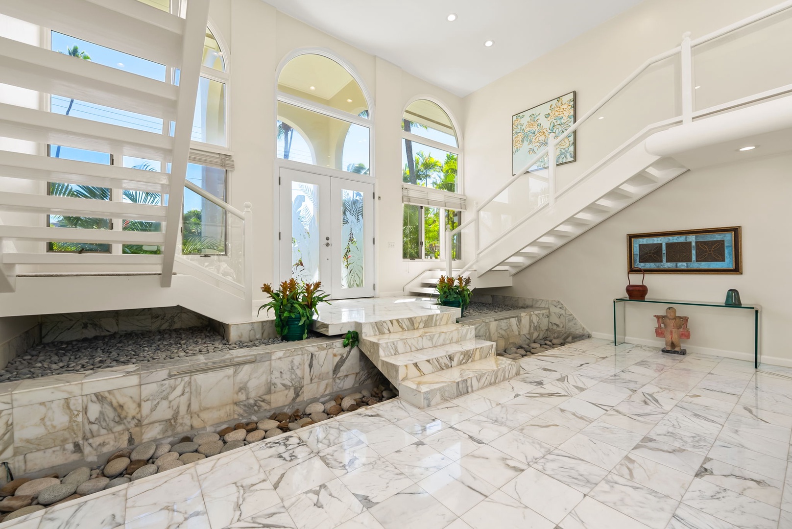 Honolulu Vacation Rentals, Kahala Oasis - Grand foyer featuring a marble staircase and an arched entryway, creating a stunning first impression.