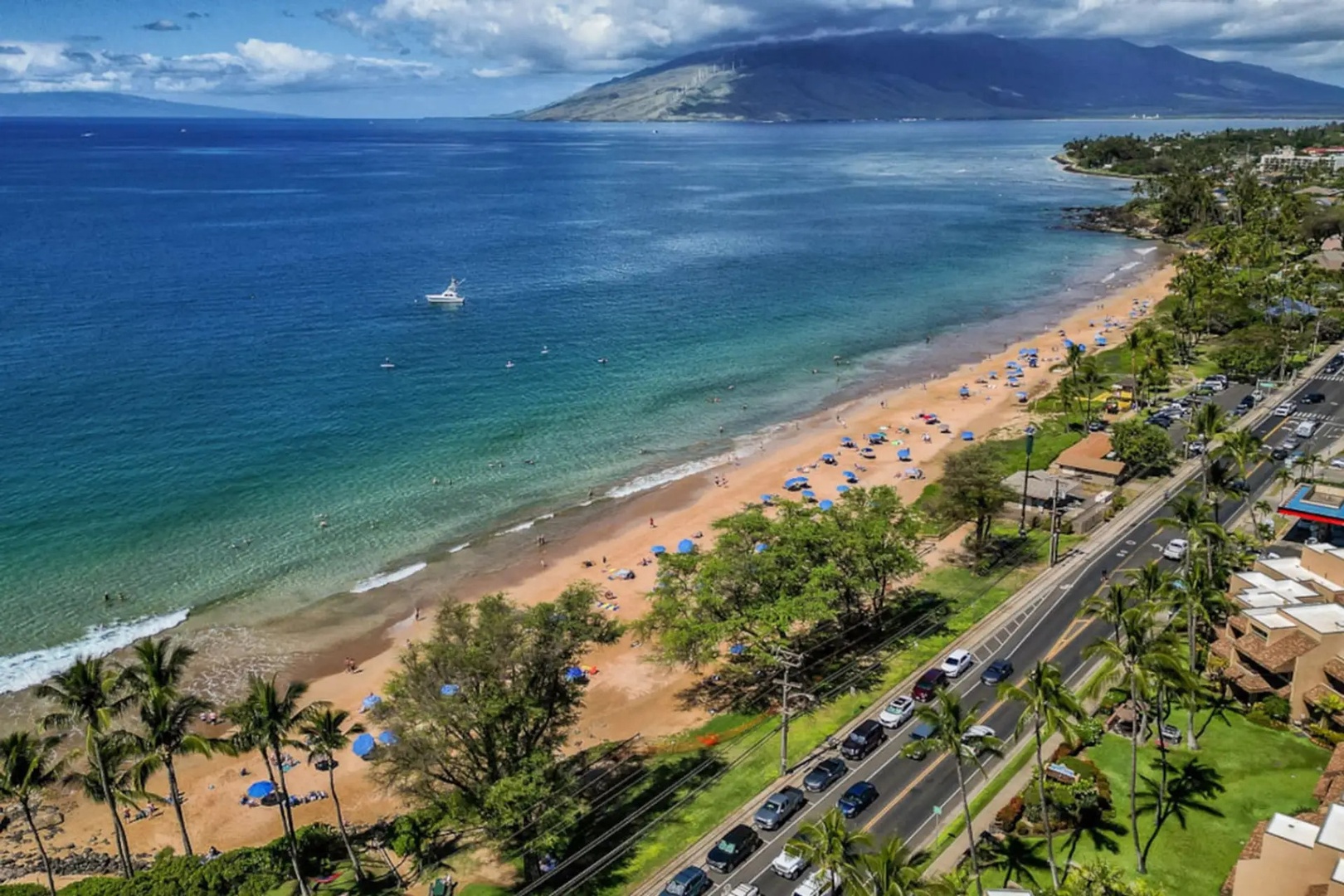 Kihei Vacation Rentals, Kamaole Beach Royal 610 - From above, the coastline curves past condos and open water toward the mountains.