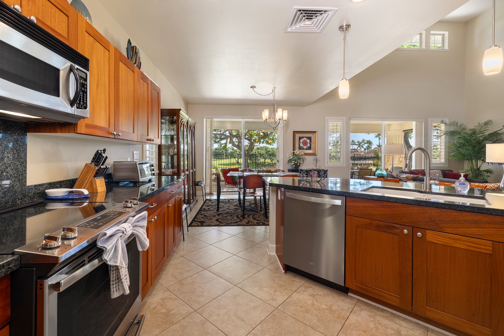 Your fully equipped kitchen features granite counters, stainless appliances, and opens to a bright dining area with garden views.