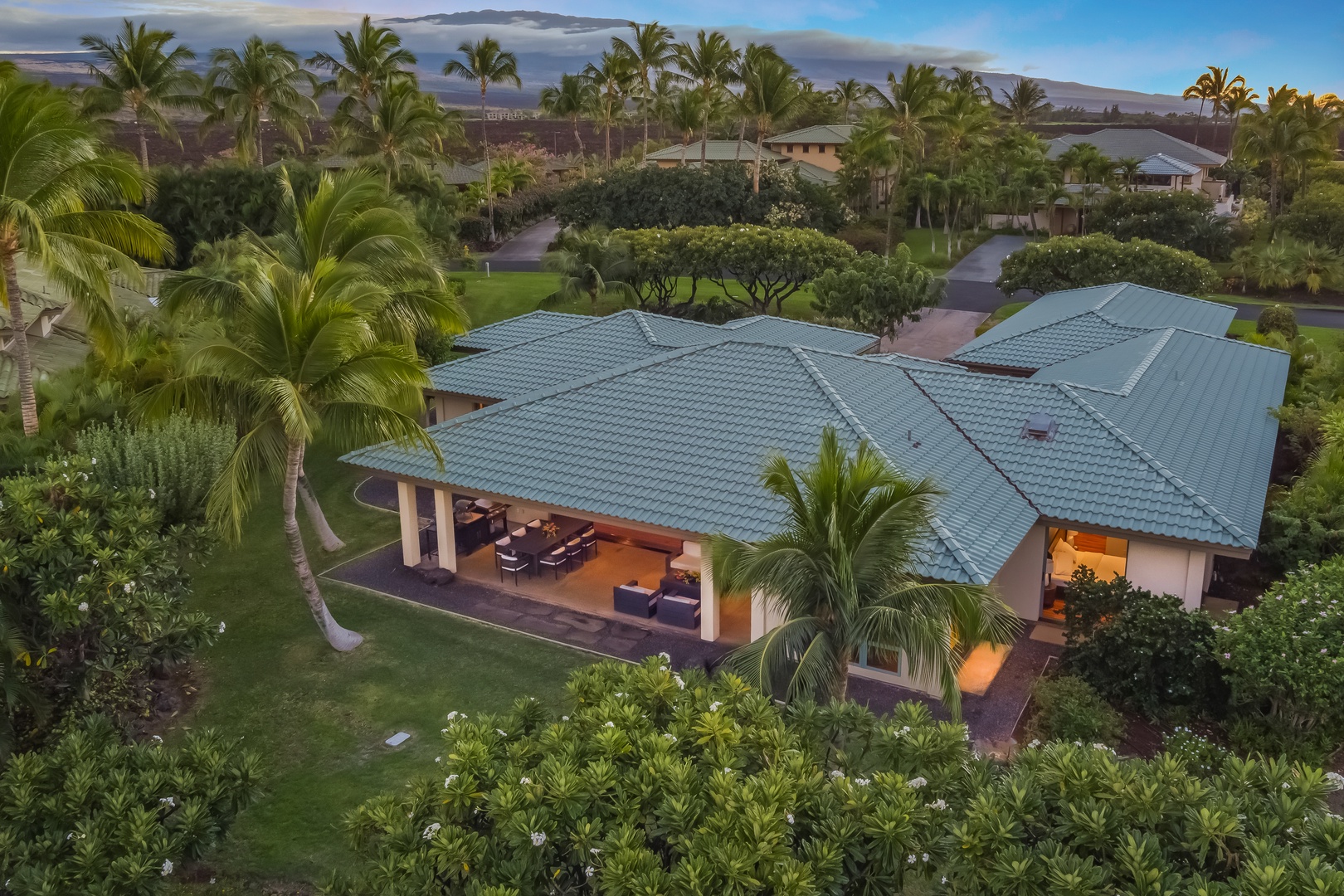 Kamuela Vacation Rentals, Champion Ridge Elegance - Aerial view of the immaculate property, showcasing the main lanai surrounded by lush tropical greenery and privacy.