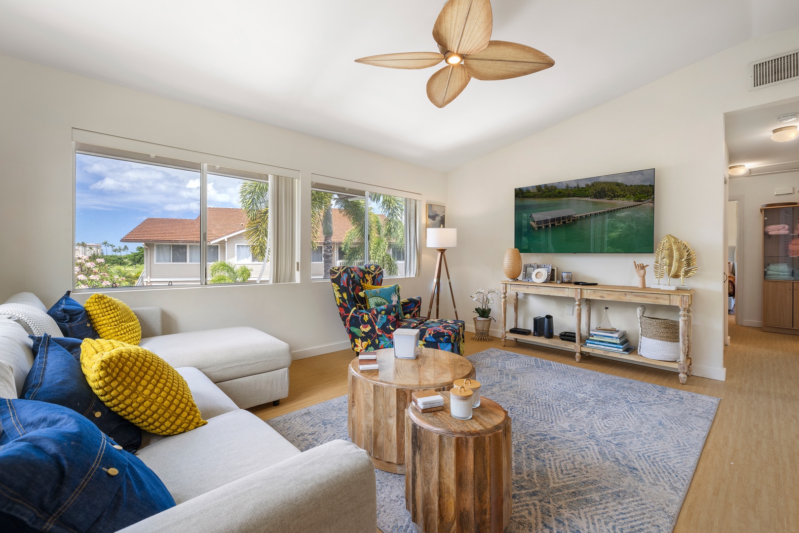 Unwind in your bright living space with coastal artwork, natural wood accents, and colorful tropical touches creating the perfect beach retreat.