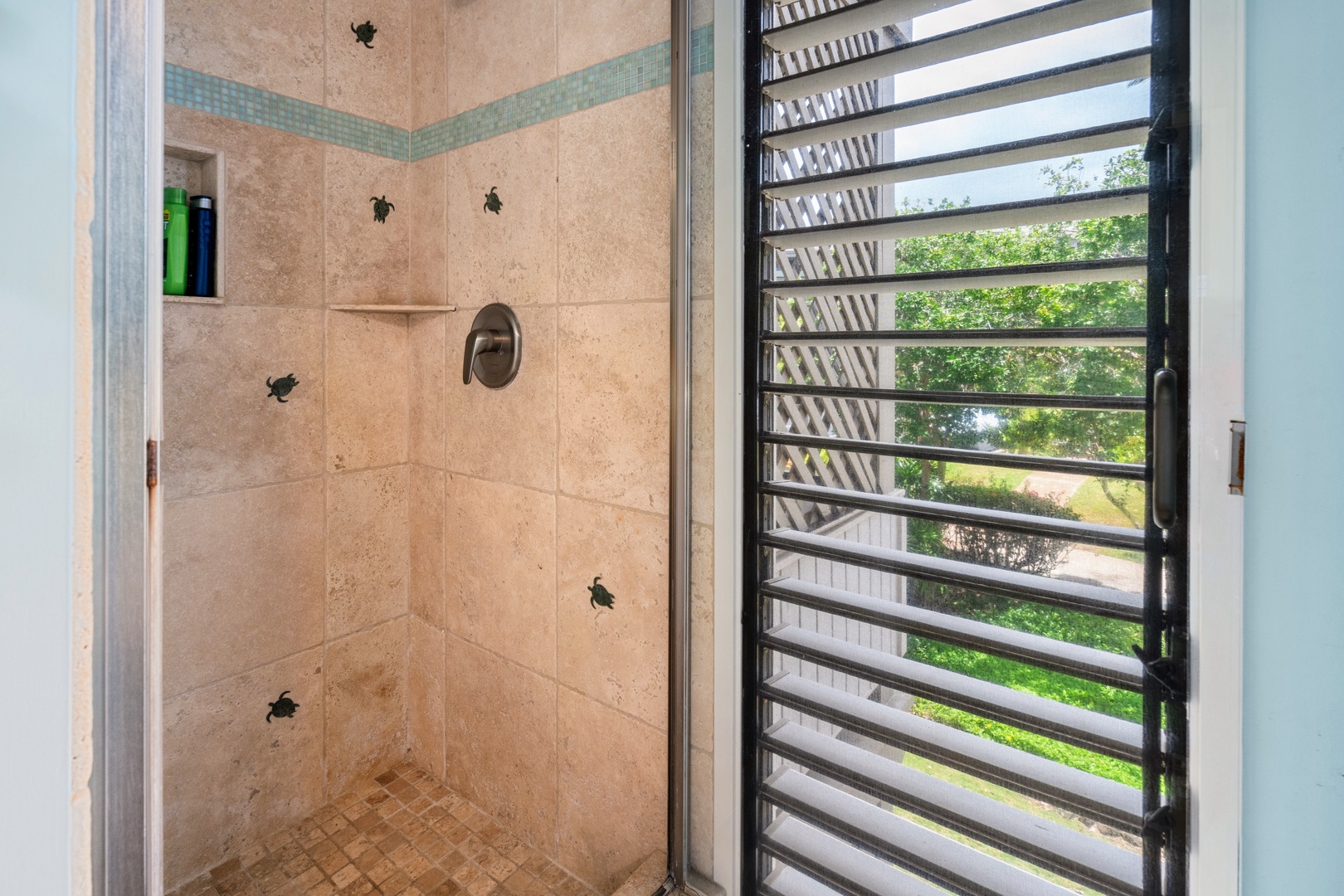 Kihei Vacation Rentals, Wailea Ekolu 204 - Rinse the sand off in a shower dotted with tiny mosaic sea turtles, garden greenery filling the louvered window beside it.