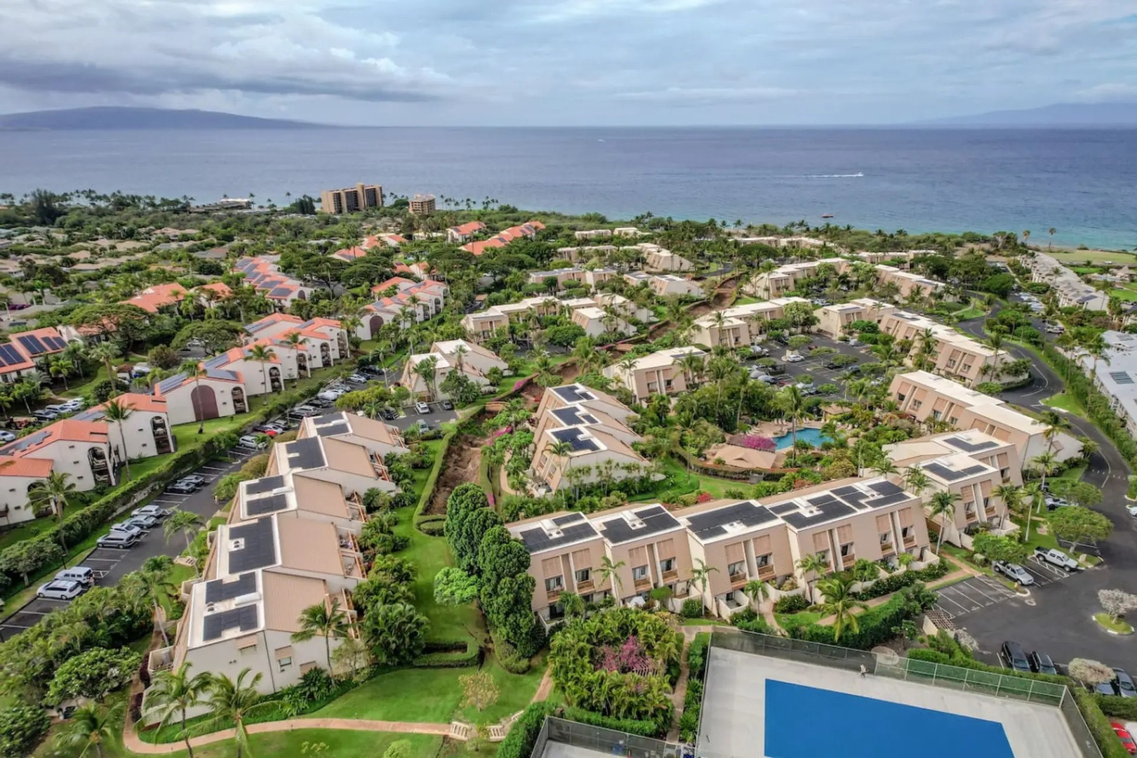 Kihei Vacation Rentals, Maui Kamaole E103 - Red-roofed rooftops spread toward the ocean, the whole neighborhood visible from above.