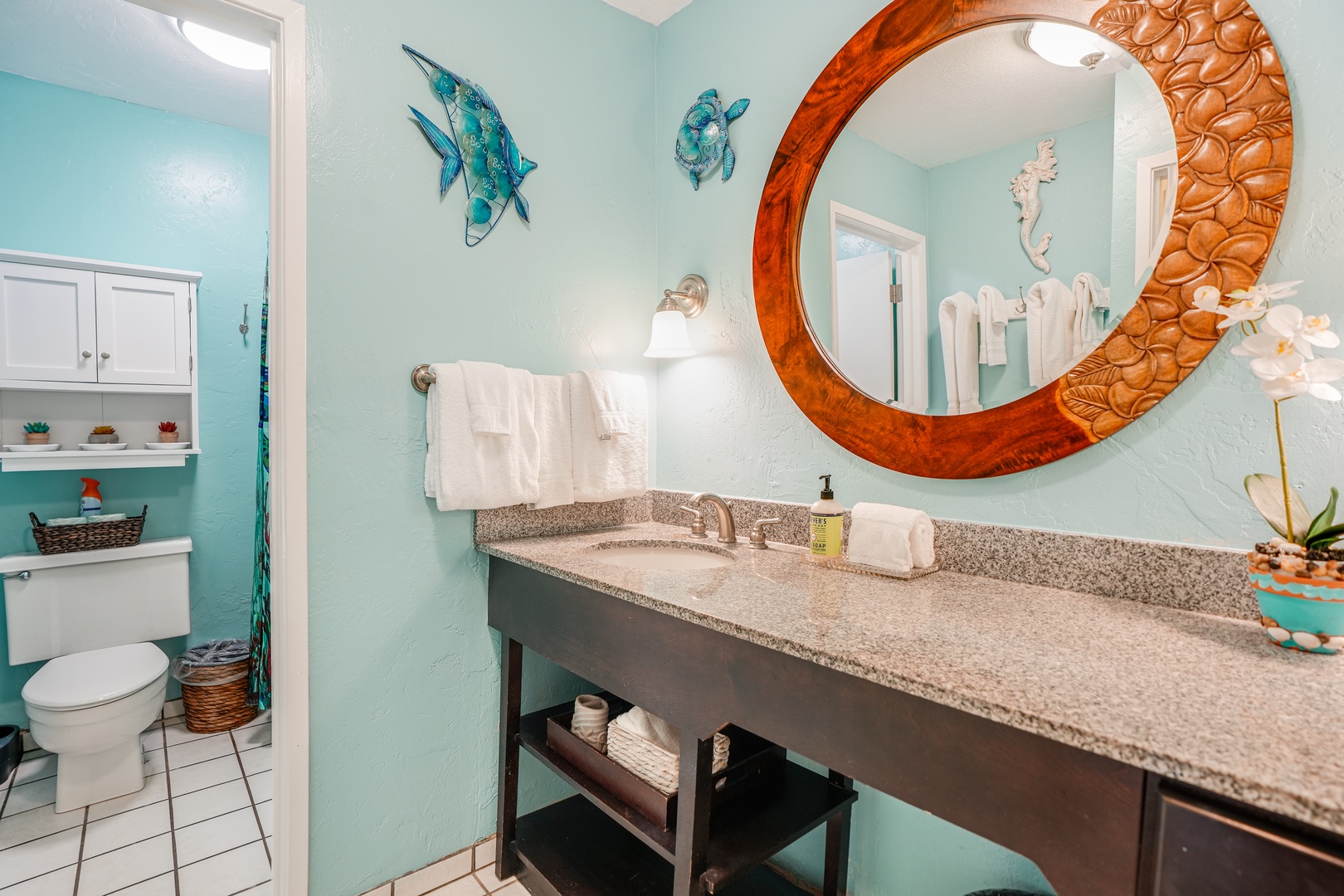 Kapaa Vacation Rentals, Nani Hale - Refresh in the vibrant bathroom featuring colorful Hawaiian touches, a spacious vanity, and plenty of shelving for personal items.