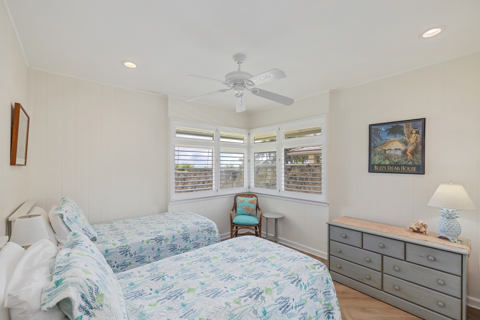 Kailua Vacation Rentals, Hale Moana Lanikai - This inviting guest room features twin beds adorned with cheerful, botanical-themed bedding, creating a refreshing atmosphere