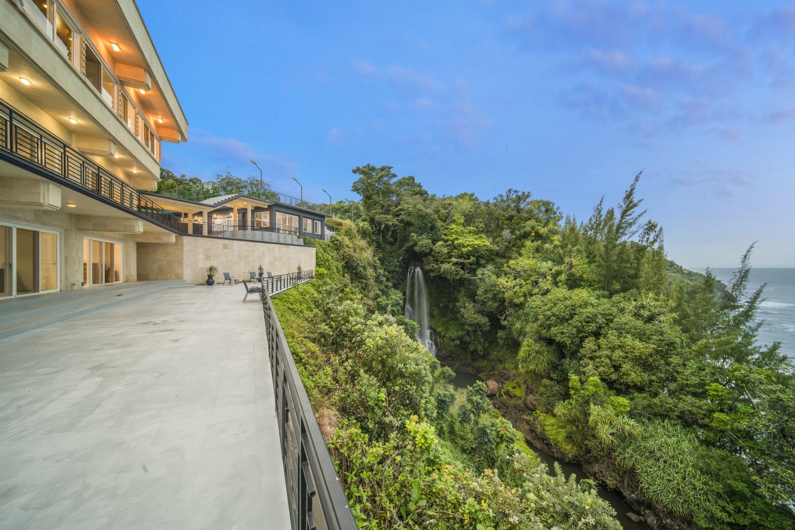 Ninole Vacation Rentals, Waterfalling Estate - Deck outside kitchen and great room w/private waterfall in the background.