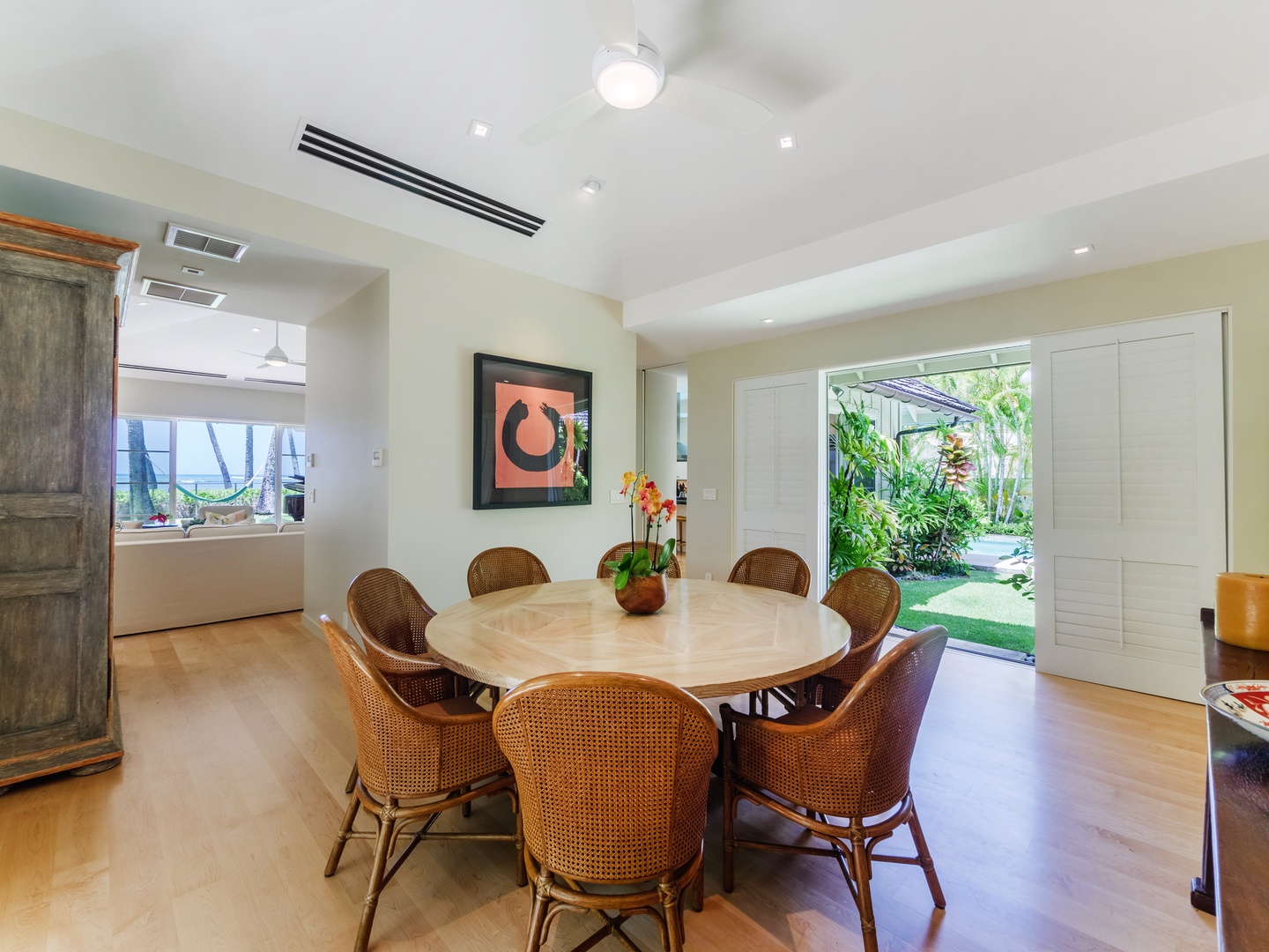 Honolulu Vacation Rentals, Paradise Beach Estate - Elegant dining table seating eight, seamlessly connecting to the outdoors for a refreshing dining experience amidst nature's embrace.