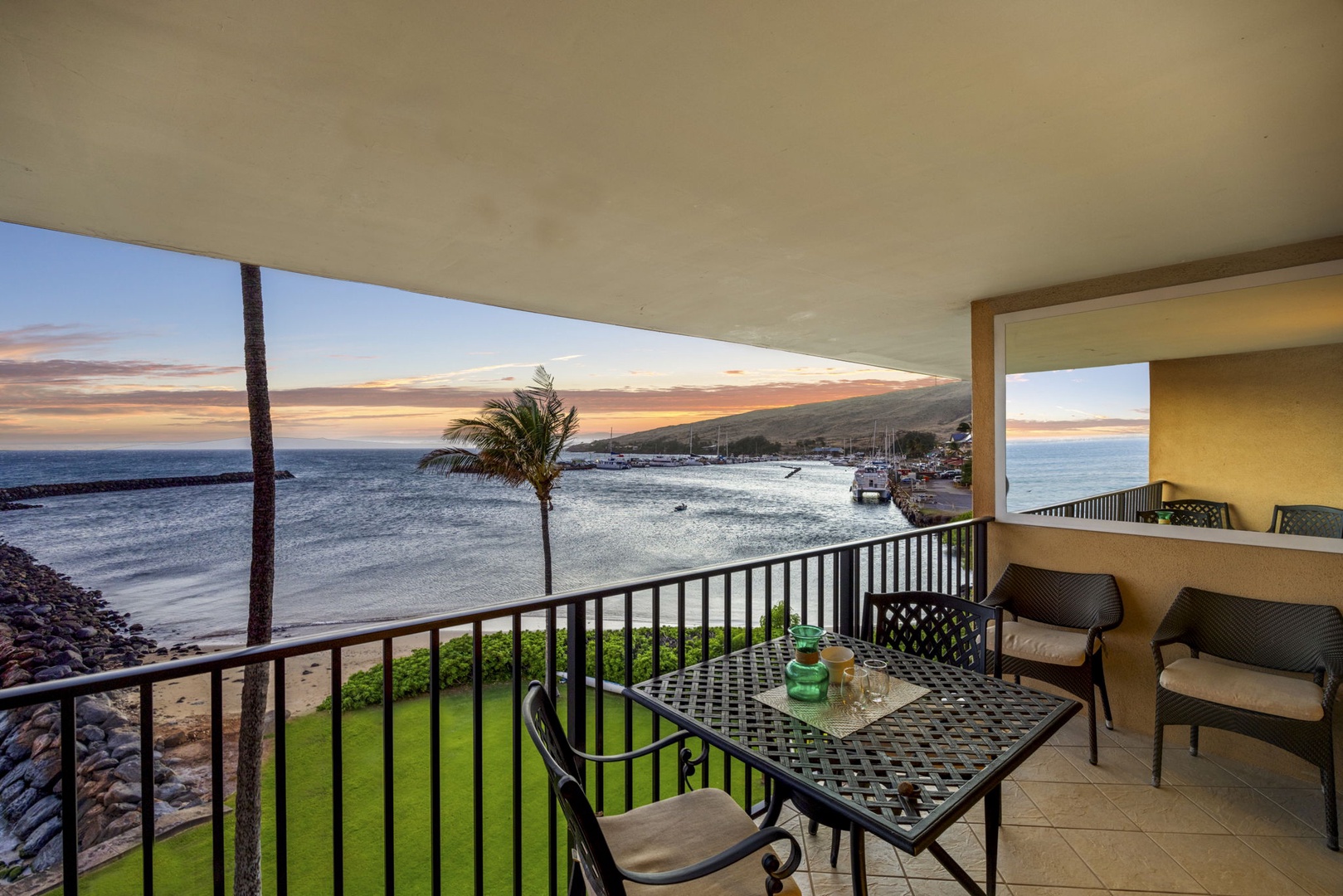 Wailuku Vacation Rentals, Milowai 310 - Sunset colors stretch from the palm tree to the marina, with the table for two set right at the rail.