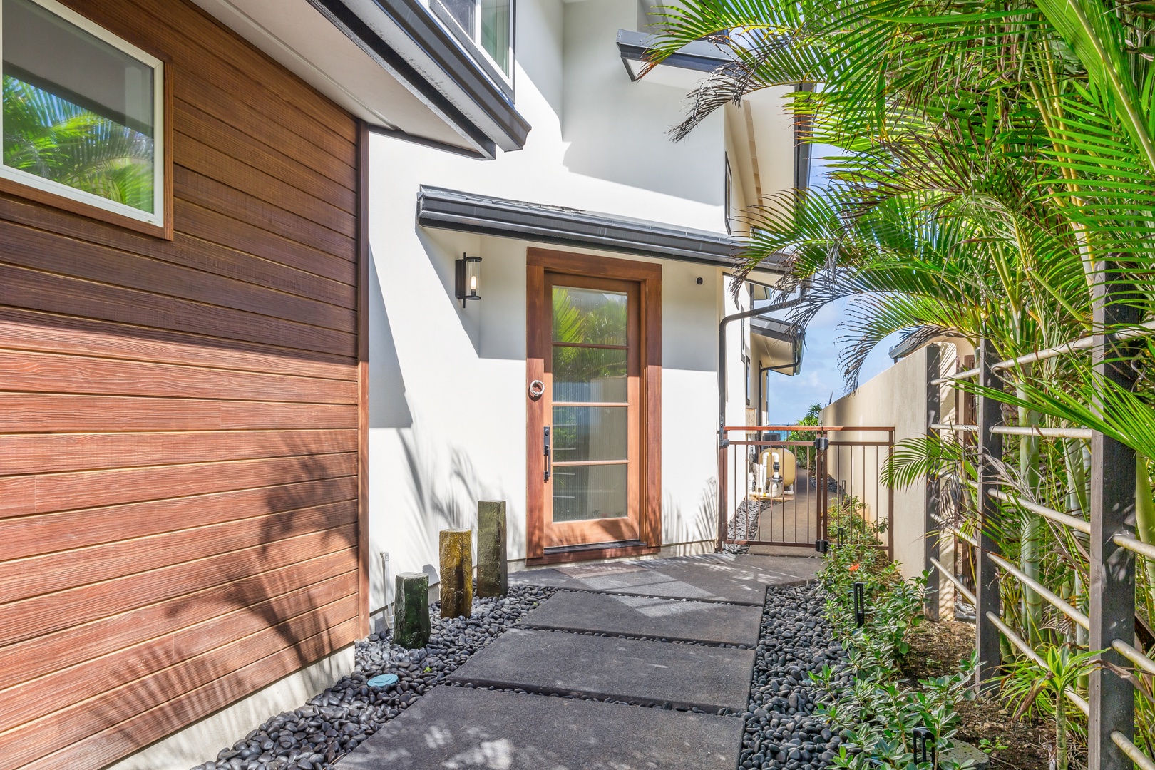 Laie Vacation Rentals, Majestic Mahakea Oceanfront Oasis - Charming front entrance surrounded by vibrant greenery and a welcoming design.