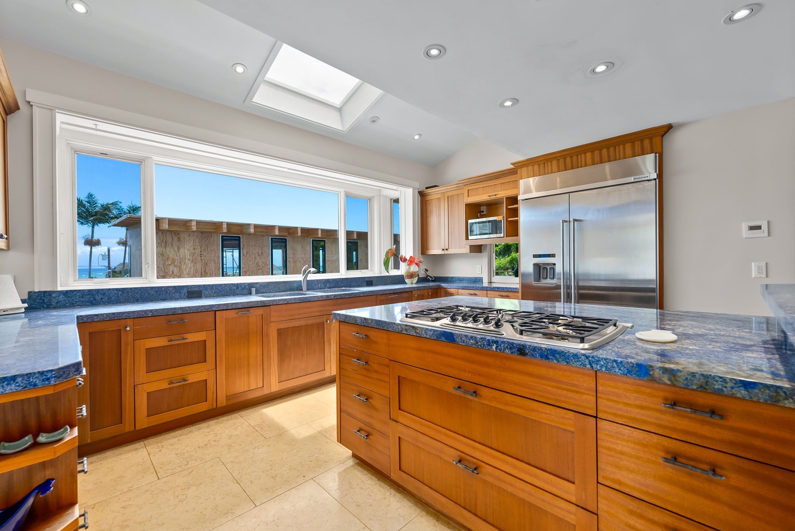 Kailua Vacation Rentals, Leaf House - Indulge in your gourmet kitchen where stunning ocean views meet functionality. Warm wood cabinetry, sleek granite counters, and top-tier appliances make cooking feel effortless while natural light pours through the skylight above.