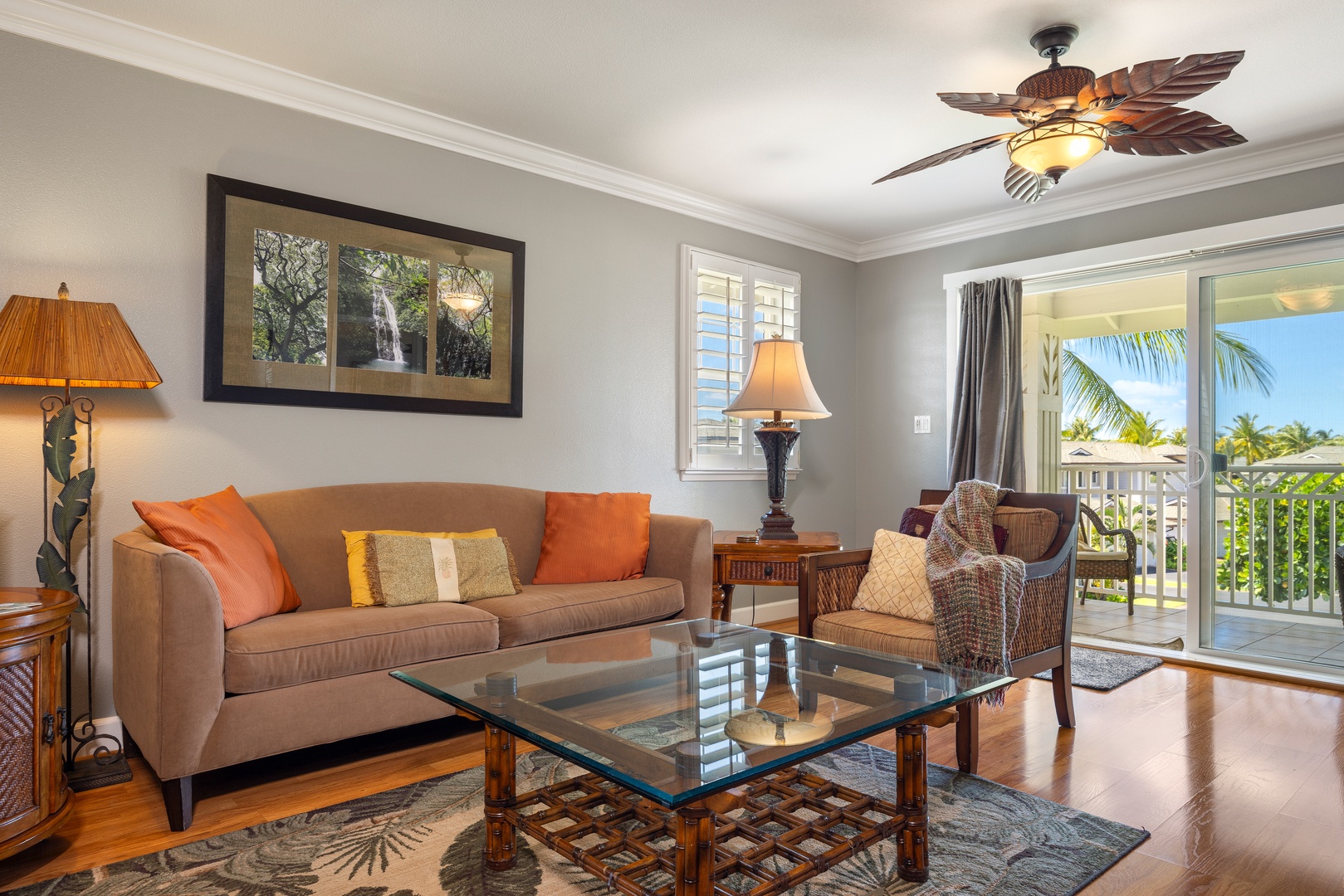 Unwind in your stylish living room with tropical views through the sliding doors and a unique palm leaf ceiling fan overhead.