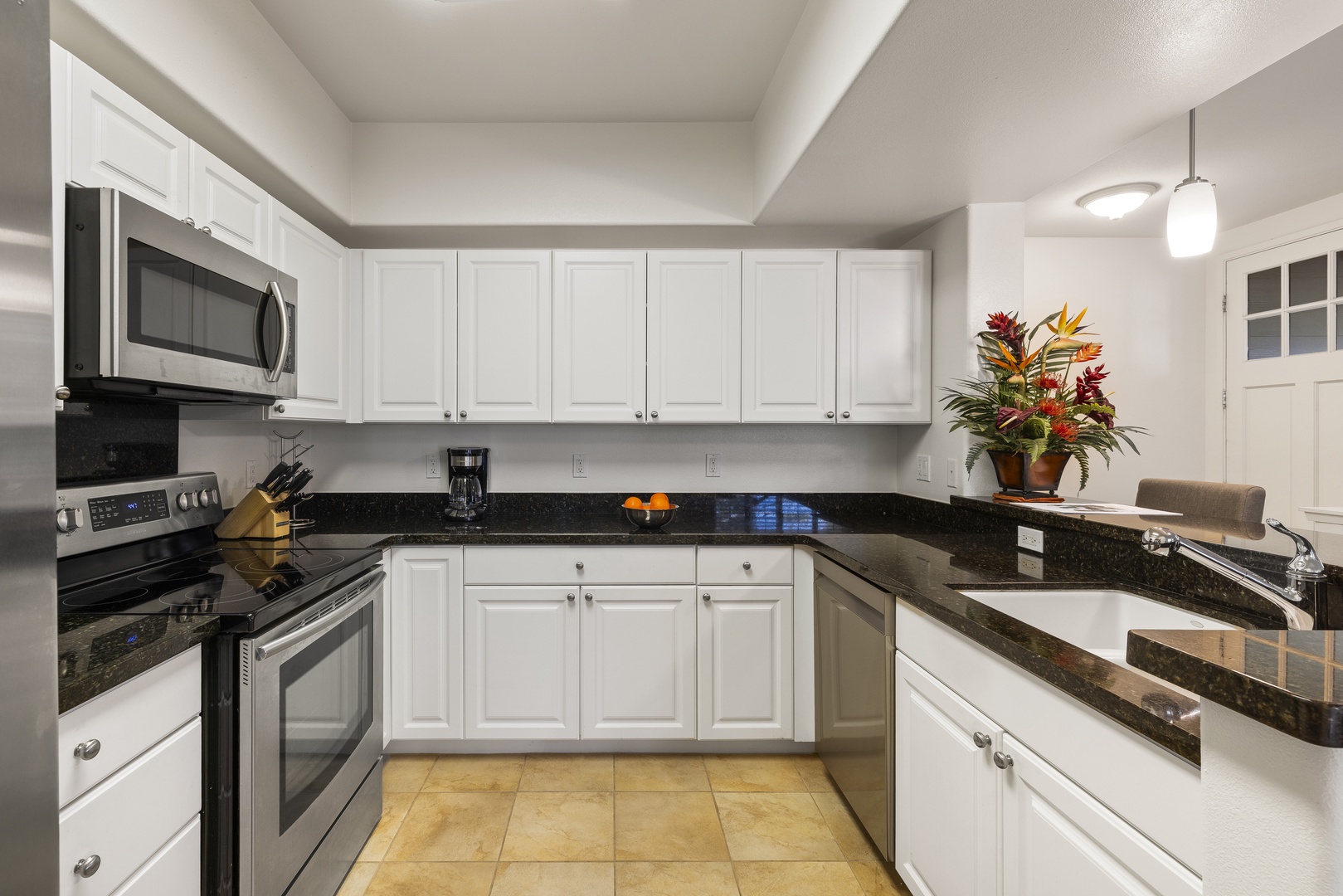 The well-equipped kitchen features granite countertops, stainless steel appliances, and everything needed for meals at home.