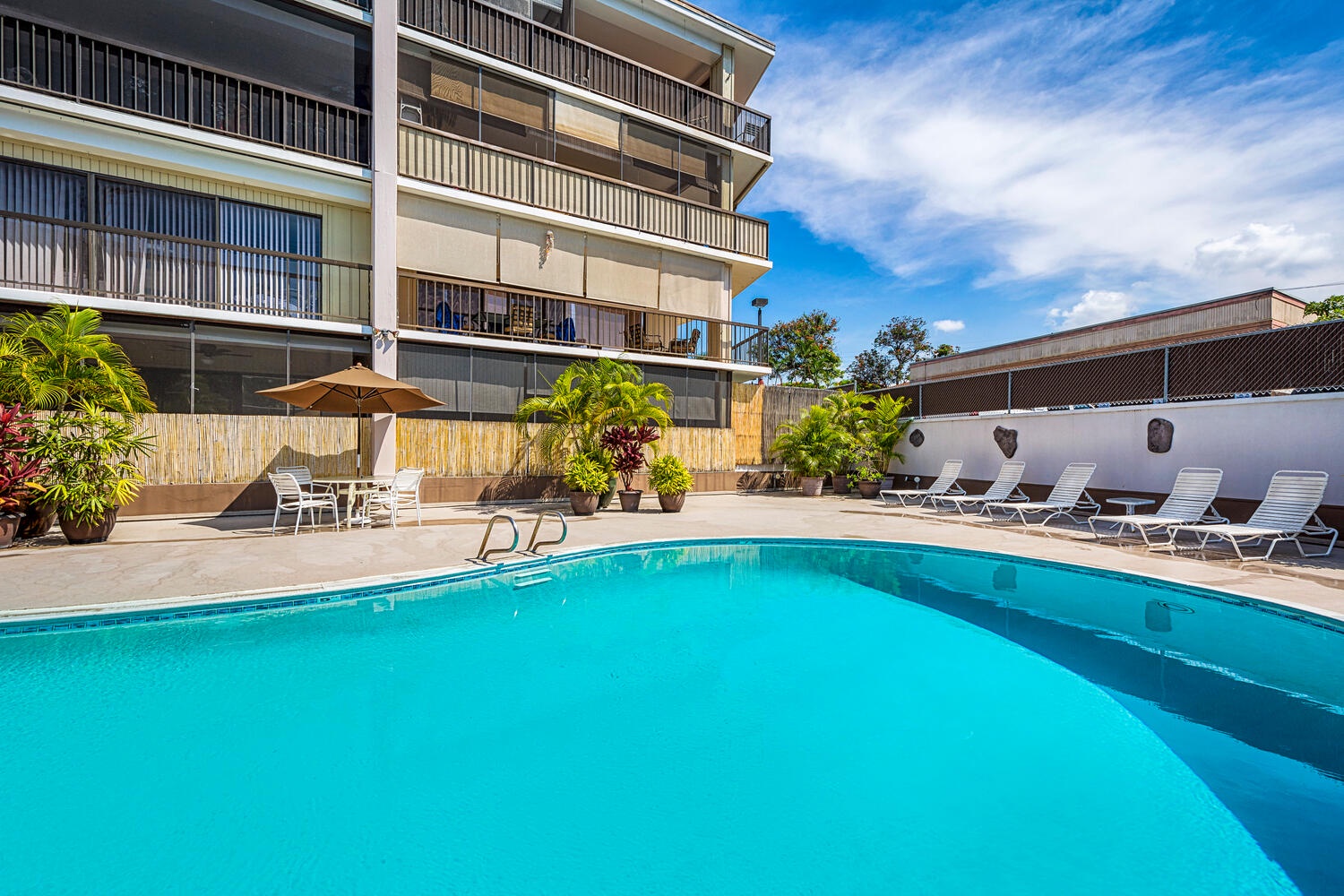 Kailua Kona Vacation Rentals, Kona Plaza 201 - Dive into crystal-clear waters surrounded by tropical plants, then lounge on comfortable chairs under the warm sun.