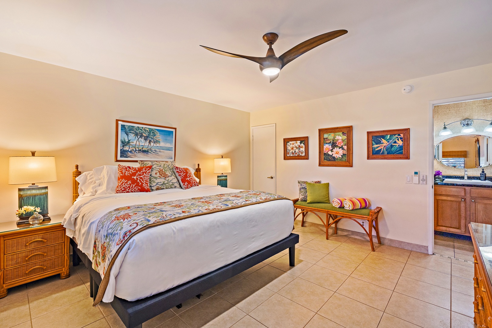 Lahaina Vacation Rentals, Kahana Sunset B4B - The bedroom at Kahana Sunset B4B offers a cozy bed, vibrant bedding, tiled floors, and island-inspired artwork.