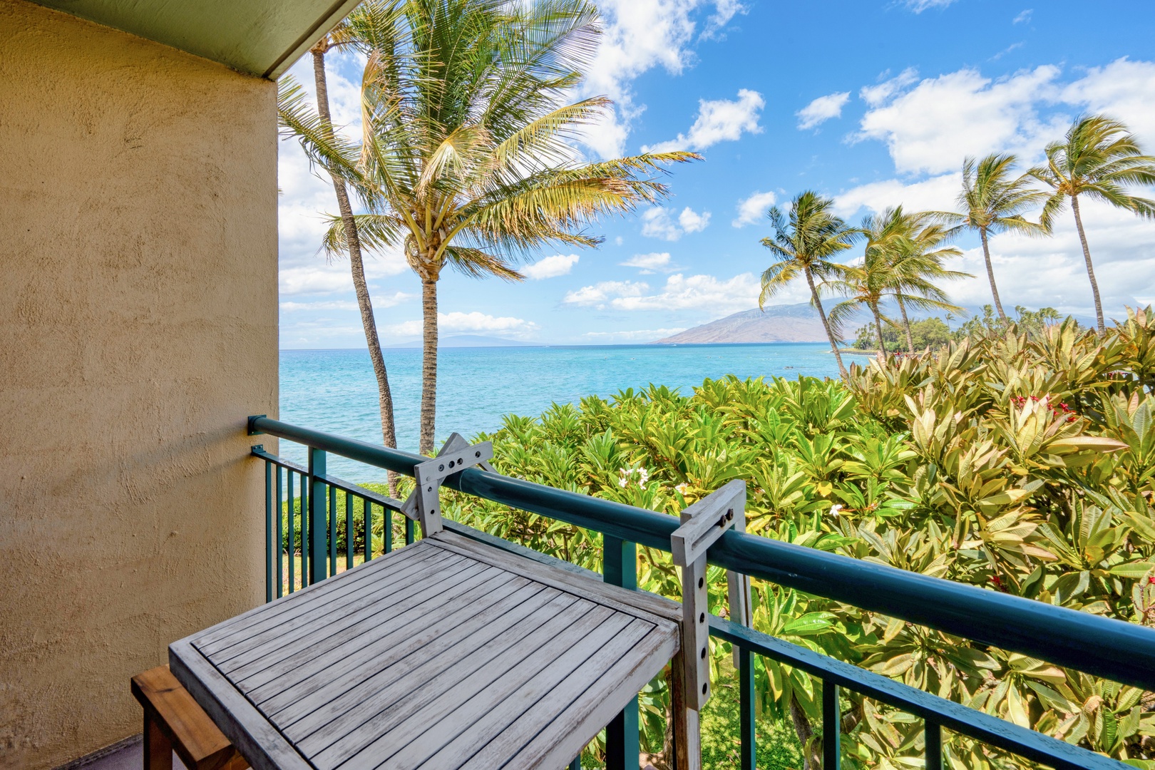 Kihei Vacation Rentals, Punahoa Beach 205 - Plumeria blooms crowd the rail below a table made for morning coffee.