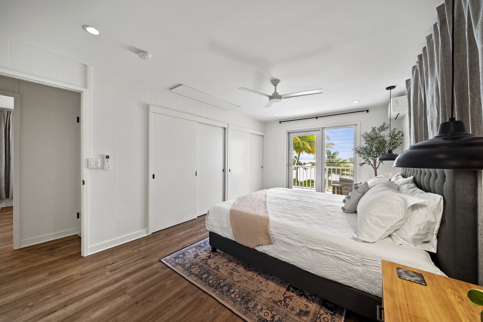 Honolulu Vacation Rentals, Honolulu Beachfront Retreat - Spacious guest suite with a king-sized bed, ceiling fan, and private lanai access — a serene retreat after island explorations.
