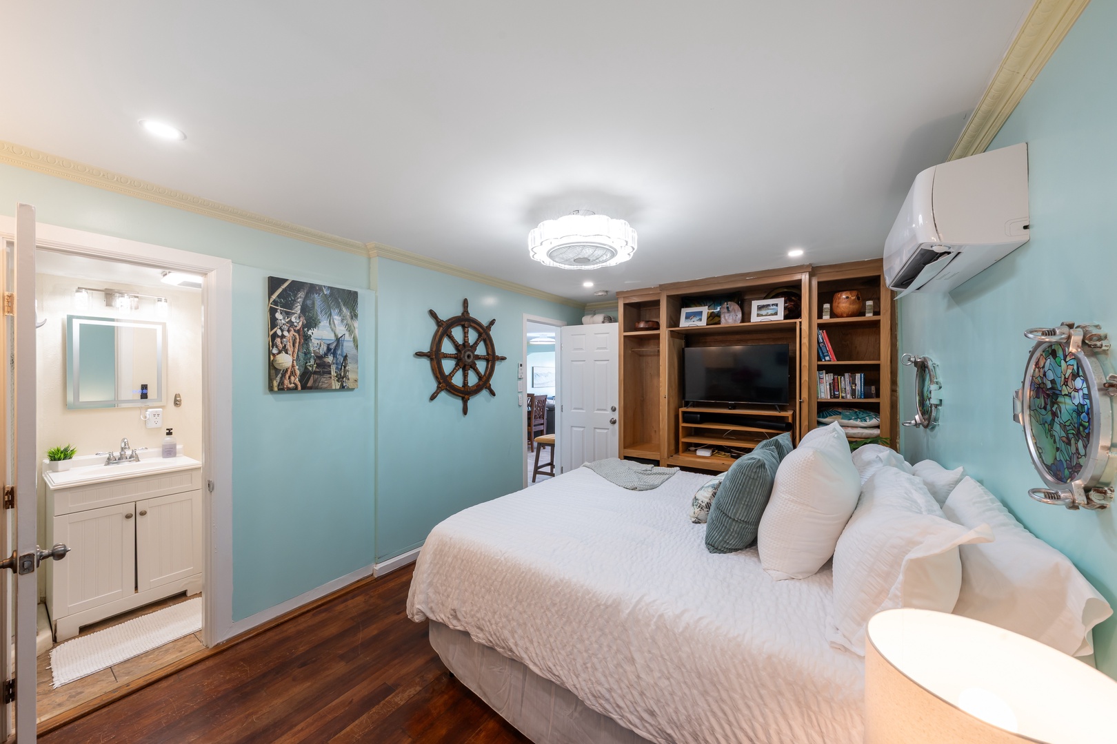 Hauula Vacation Rentals, Private Beach Paradise - Nautical-inspired bedroom with plush bedding, warm tones, and built-in entertainment.